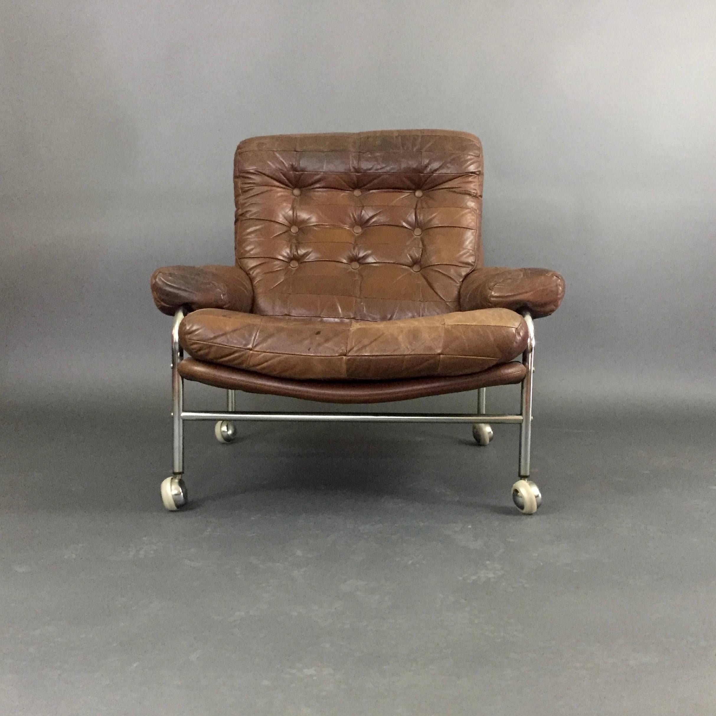 Similar to the Bruno Mathsson lounge chair, this Scandinavian example has generous proportions to the tubular chrome frame with buttoned and patchwork leather that is a classic of the 1970s design aesthetic. The seat support is curved for comfort.