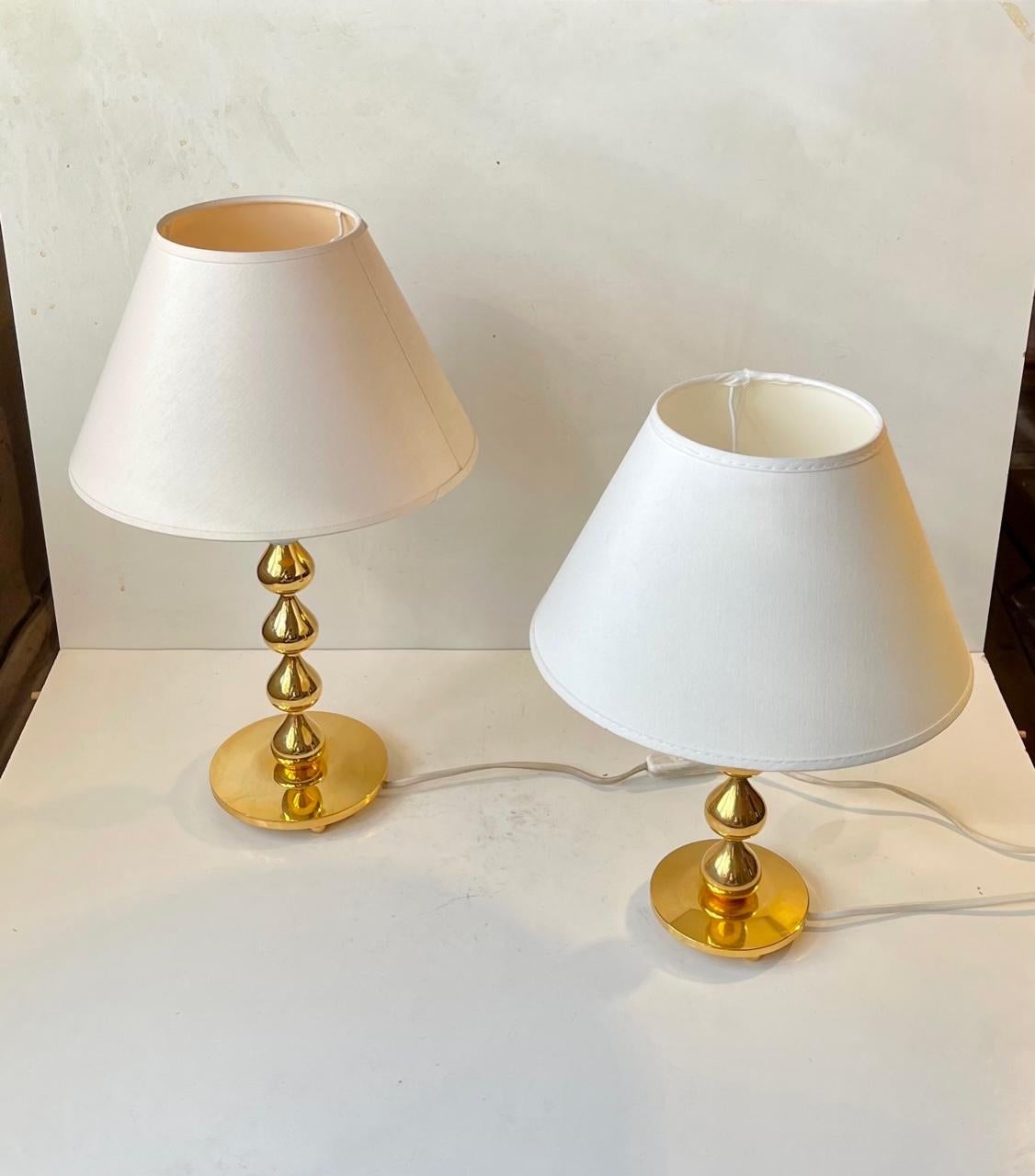 Sculptural tear drop shaped set of 24-carat gold plated Table lights designed by Hugo Asmussen for Asmussen in Denmark, circa 1960-70. Very heavy made stock in a superb quality. They come with matching white textile shades. Measurements: H: 35/45