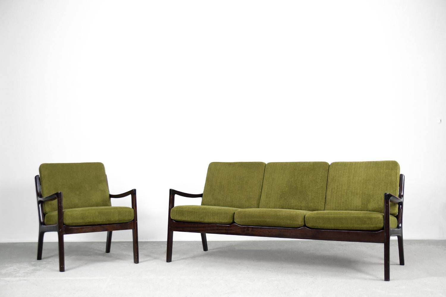 This elegant Senator lounge set, consists of a three-seater sofa and armchair, was designed by Ole Wanscher for the Danish Cado manufacture in the 1960s. The frame is made of wood in dark chocolate colour. The backrest is characterized by an
