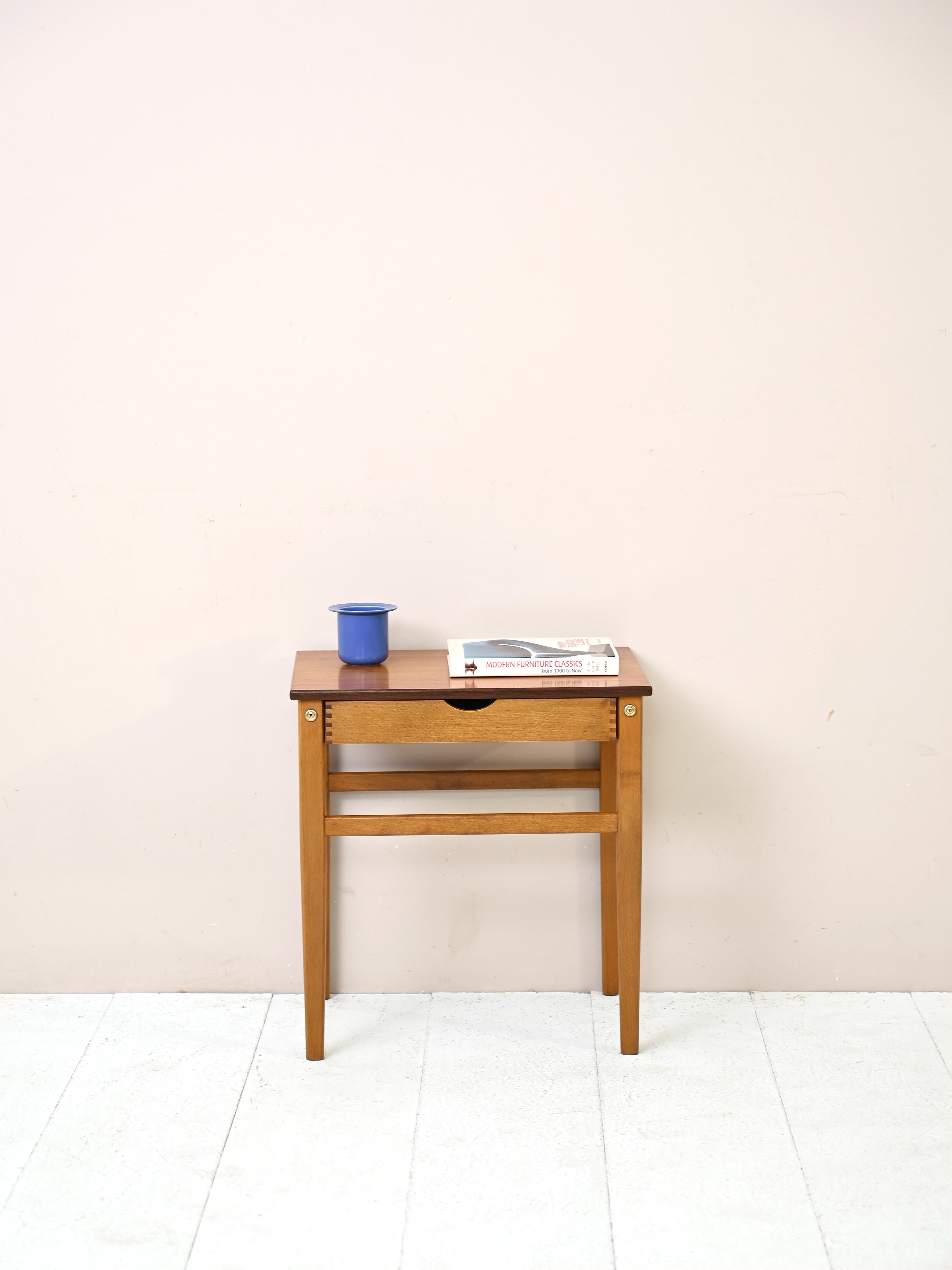 Skandinavisches Möbel aus den 1960er Jahren mit der Doppelfunktion eines Beistelltischs und eines Nachttischs.

Die Besonderheit, die dieses Stück auszeichnet, ist die beidseitige Lackierung. Die Schublade kann nämlich sowohl auf der rechten als
