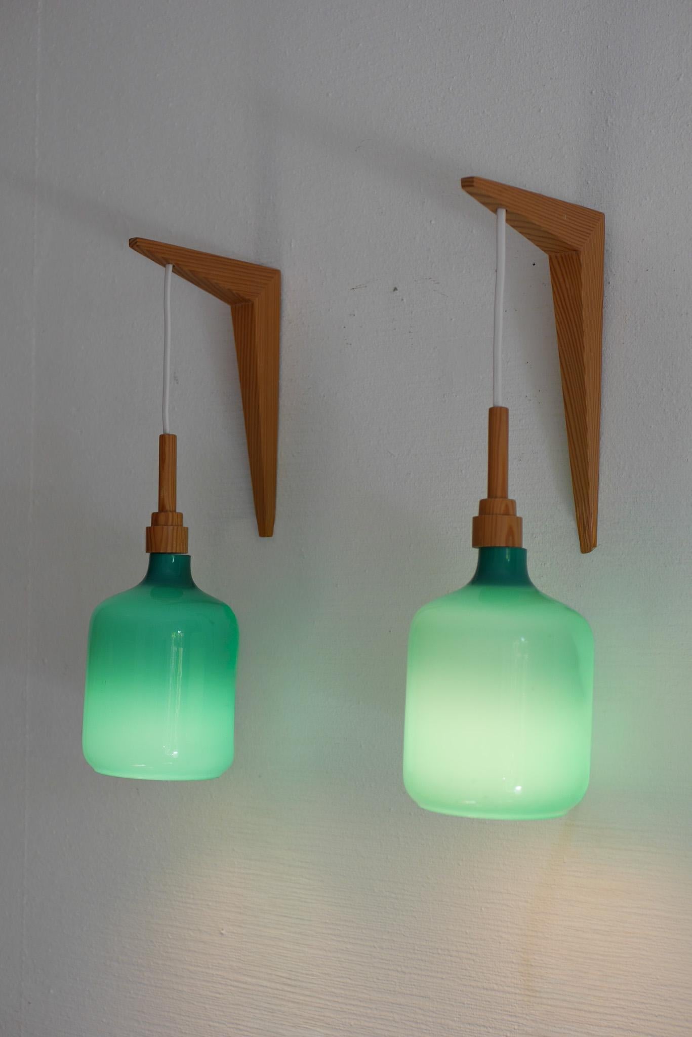 Une rare paire d'appliques murales de style moderne du milieu du siècle par Lindshammar, Suède, datant des années 1970. Chaque applique présente un verre opalin soufflé à la main, d'un extérieur turquoise profond saisissant et d'un intérieur blanc