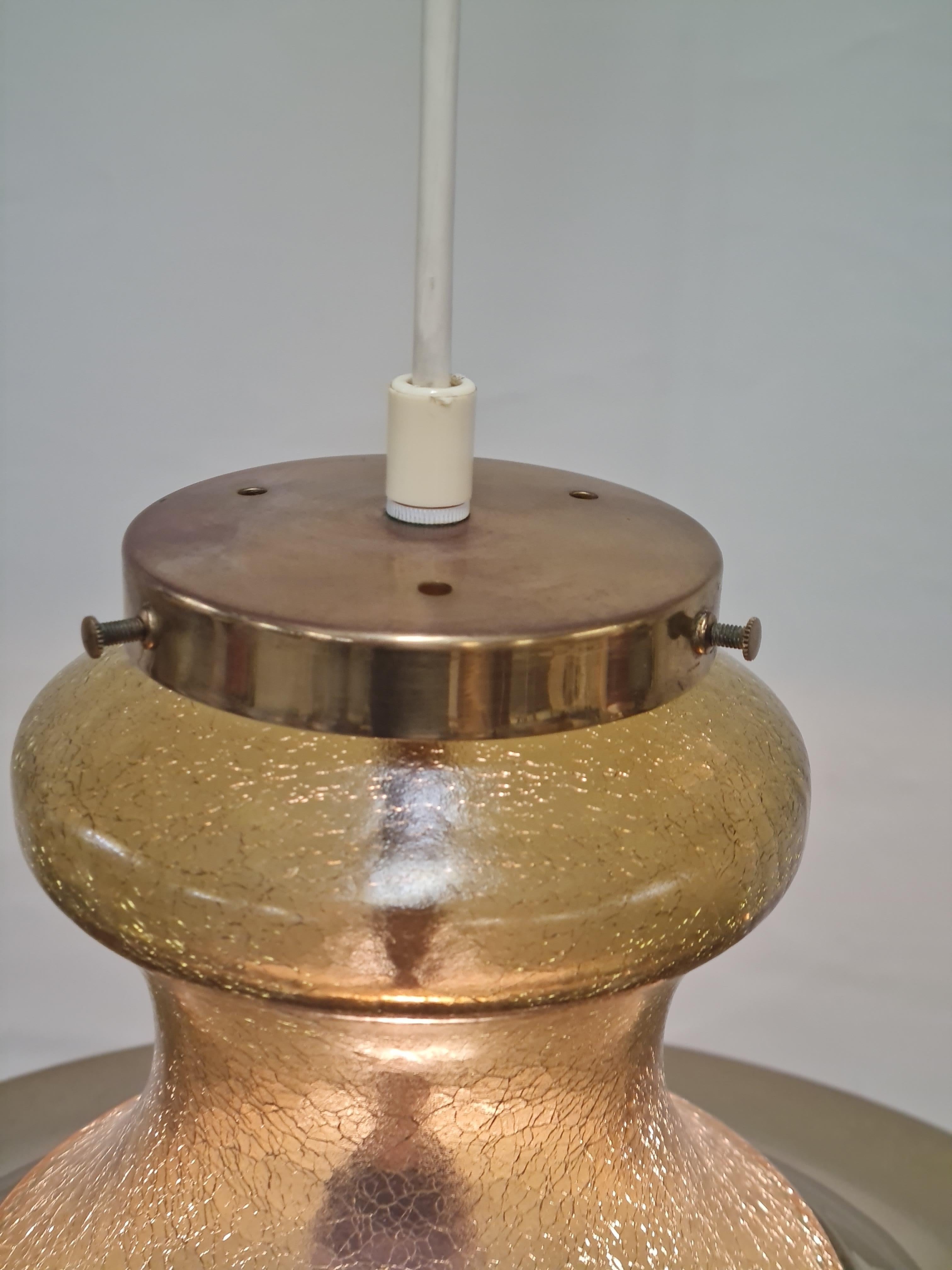 Un grande pendente a una luce composto da un bellissimo paralume a bolla in vetro crepla con un diffusore in ottone sulla parte superiore. Il design ricorda le lampade delle navi con un tocco di modernismo. Purtroppo non conosciamo il designer o il