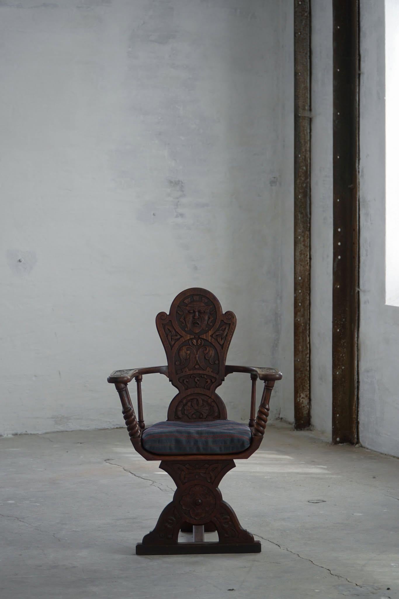 Bel exemple de l'art populaire scandinave du début du XIXe siècle, ce fauteuil sculpté à la main témoigne d'un savoir-faire exceptionnel en chêne massif. La chaise présente un dossier haut et arrondi, orné de sculptures faciales et ornementales
