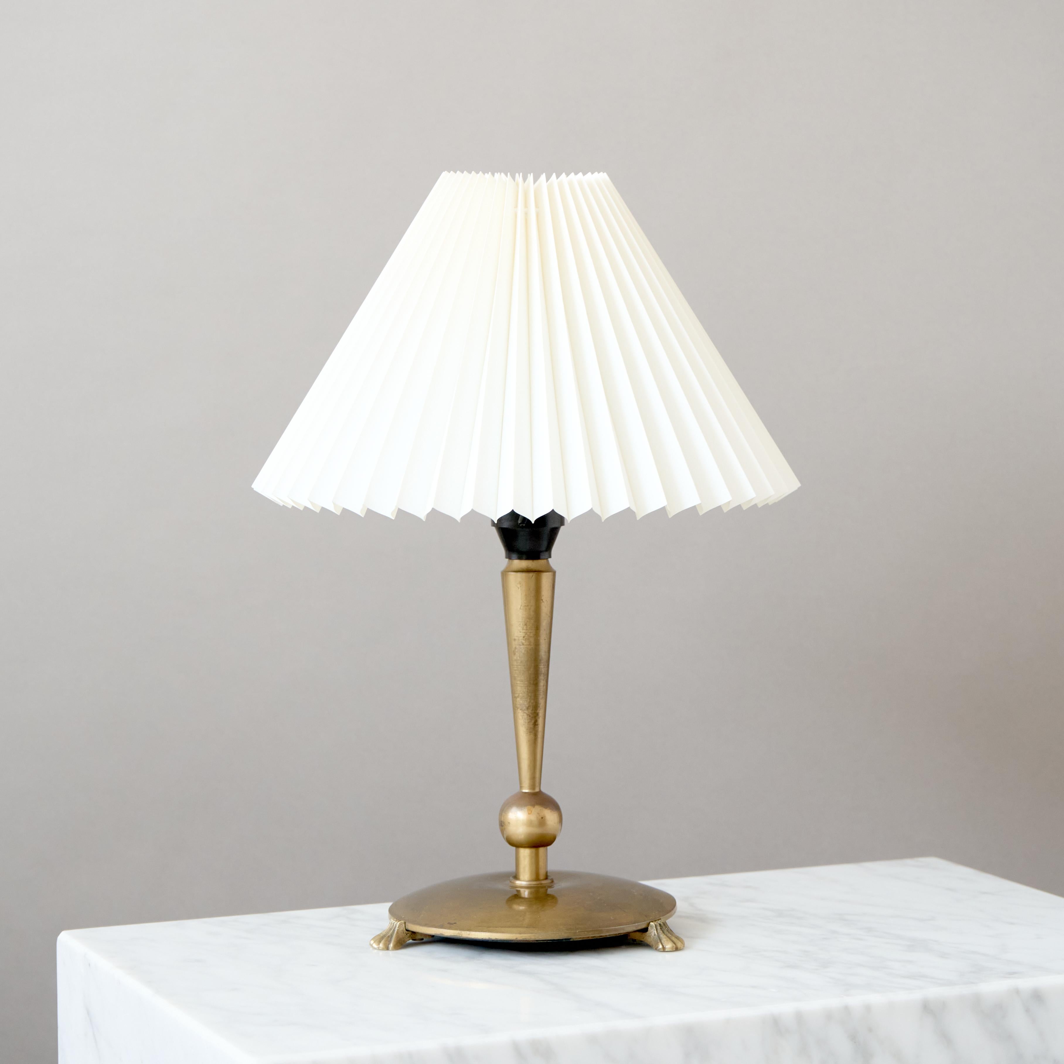 Una elegante lámpara de sobremesa de latón Art Déco / Swedish Grace.
Fabricado por un diseñador desconocido y producido en Suecia o Dinamarca, años 30.

Buen estado original. Desgaste propio de la edad y el uso. La lámpara está ligeramente