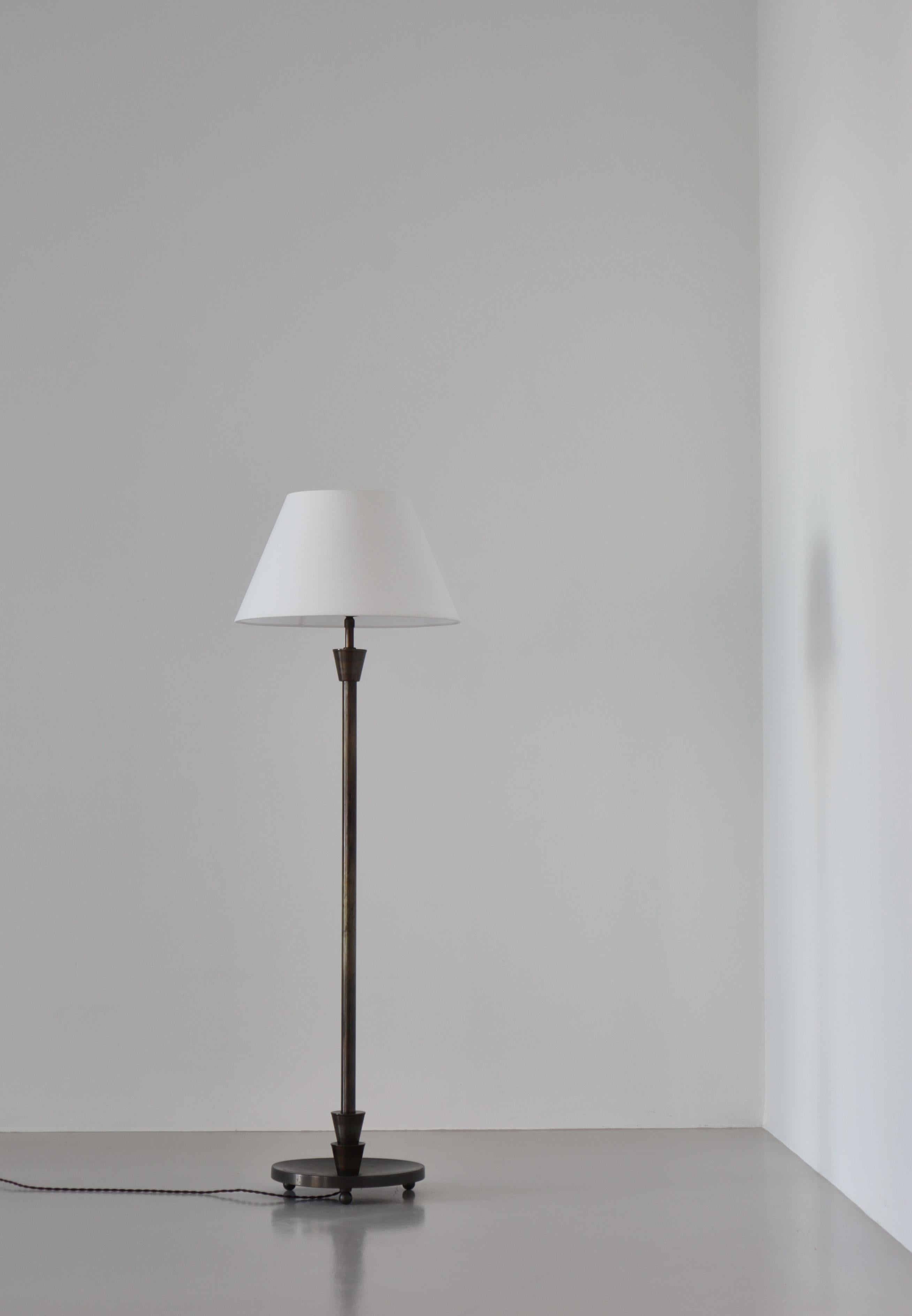 Grand lampadaire scandinave Art déco avec base bombée en bronze patiné reposant sur trois boules. Fabriqué au Danemark dans les années 1930. Dans le style de Just Andersen. Monté avec un nouvel abat-jour en lin blanc.