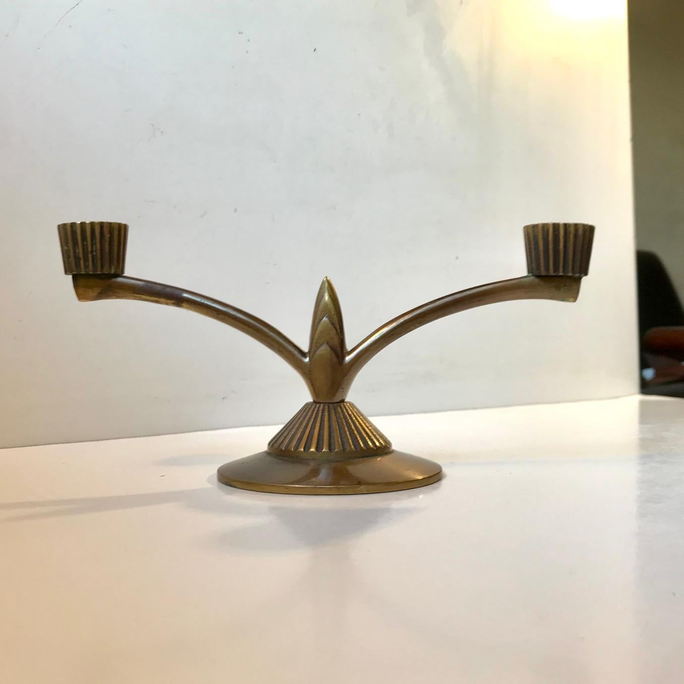 Patinated solid bronze candelabra for 2 regular sized candles. It was designed and manufactured by Tinos in Denmark during the later part of the 1930s. Its features architectural details and distinct Art Deco styling. Measurements: W: 23 cm, H: 11