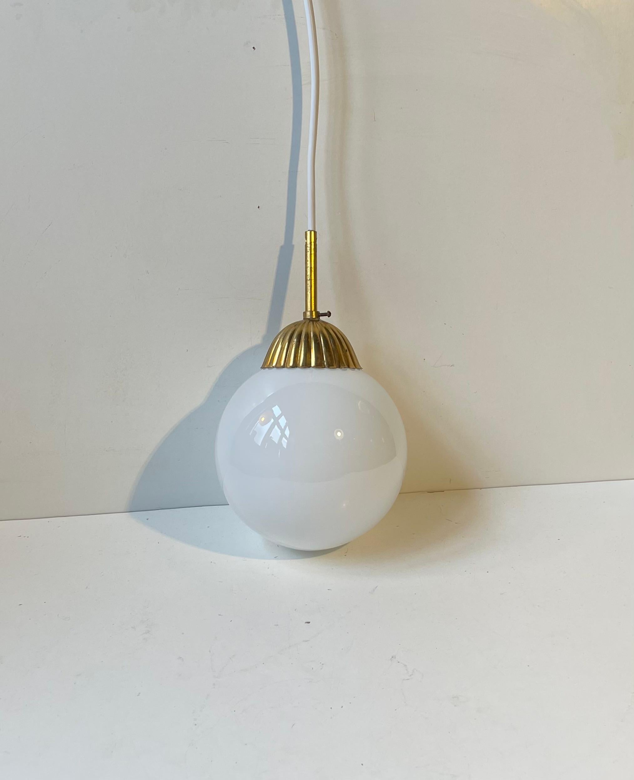 Lampada a sospensione in stile Art Déco o Bauhaus con paralume sferico in vetro opalino bianco e piano scanalato in ottone. Prodotto in Scandinavia negli anni '40 o '50. 

Sono stati installati 2,5 metri di nuovo cavo bianco sicuro e una presa fino