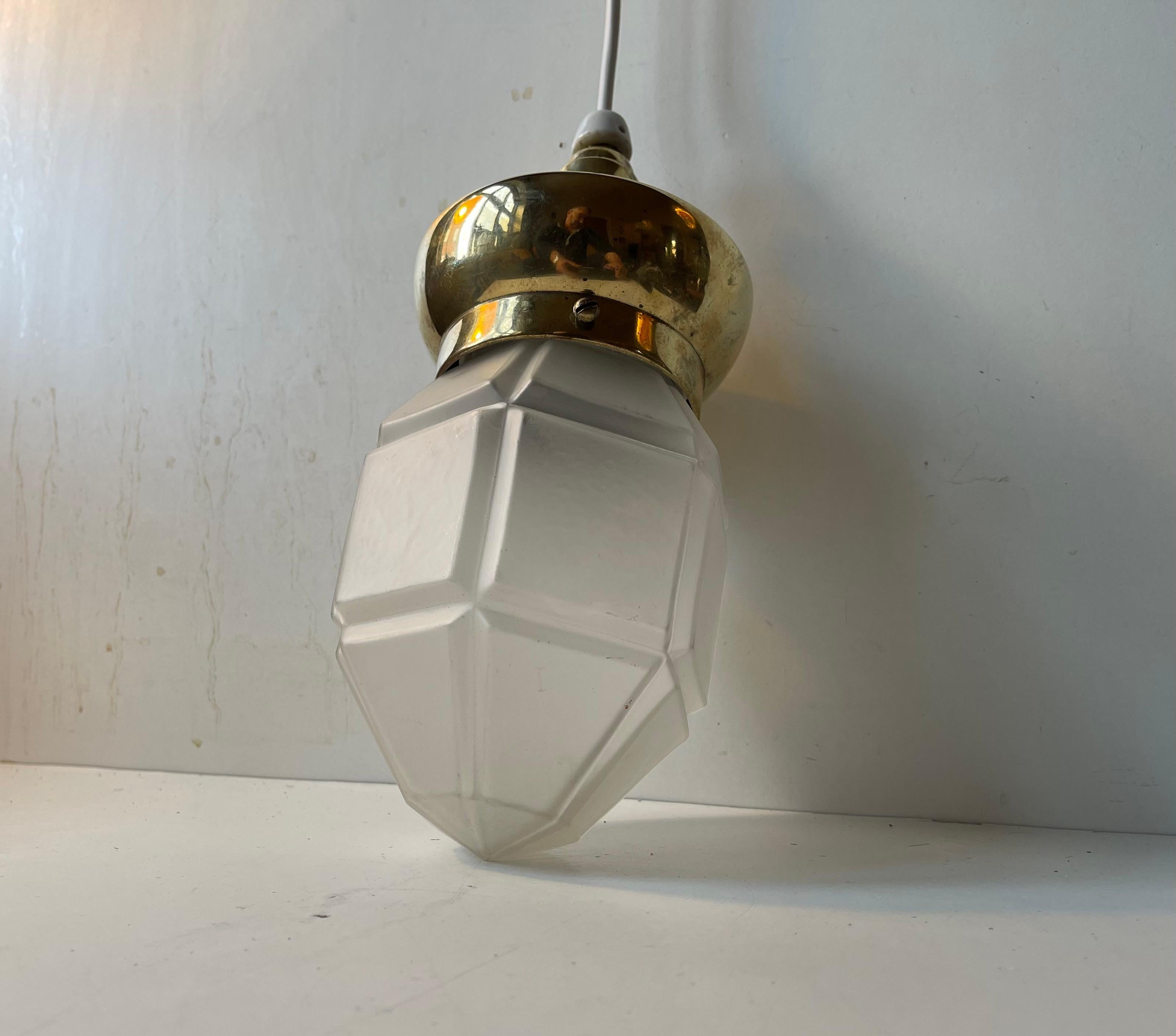 Una plafoniera degli anni '30 composta da un grande piano in ottone e da un paralume esagonale in vetro sfaccettato e satinato. È stato realizzato da un produttore sconosciuto in Scandinavia durante gli anni '30. Adatta come lampada a sospensione