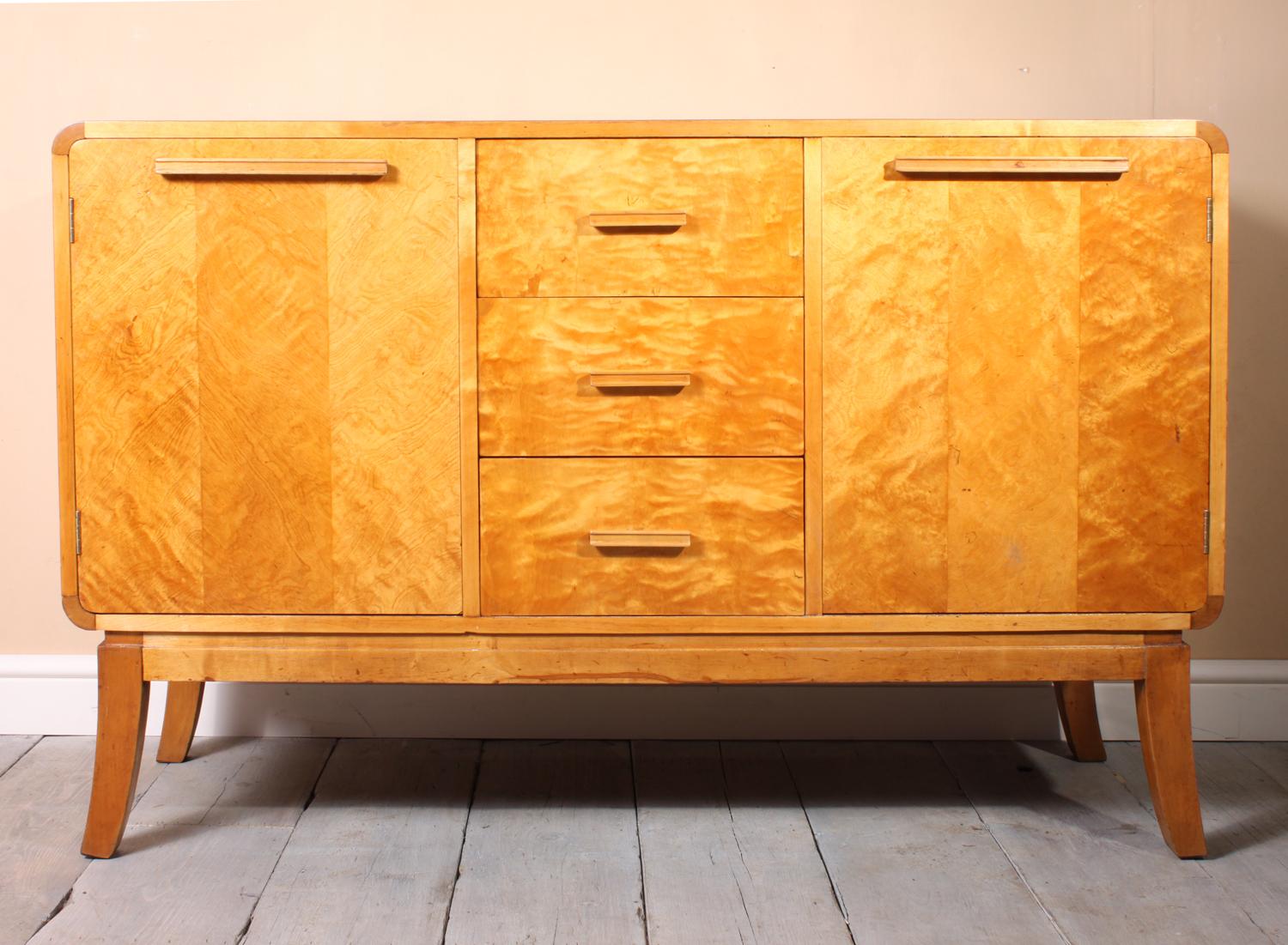 Scandinavian Art Deco sideboard

An Art Deco sideboard produced in Norway in the ear 1950s this sideboard has two cupboards and three central drawers the wood has been restored and fully hand polished using shellac and is excellent condition