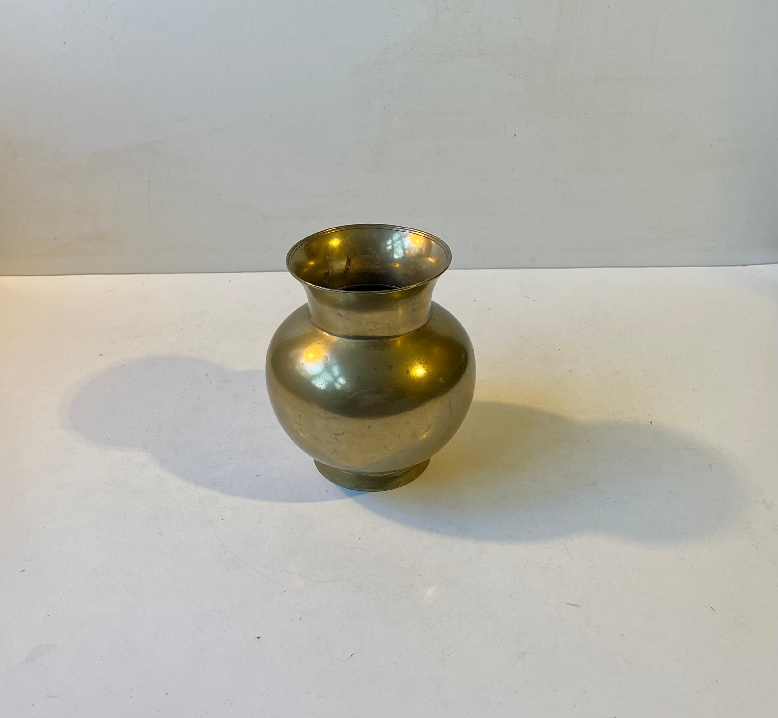 Heavy Scandinavian vase in solid bronze. Perimeter ribbings/tiers engine-turned to its top. Markings by an unknown Scandinavian maker/designer in a style reminiscent of Just Andersen and Tinos Copenhagen. Measurements: H: 15 cm, Diameter: 13/9