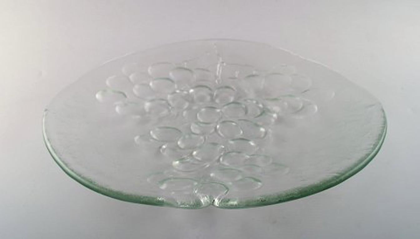 Verre d'art scandinave. Plat soufflé à grande bouche orné d'une grappe de raisin, années 1960.
En très bon état.
Mesures : 34.4 cm x 5 cm.