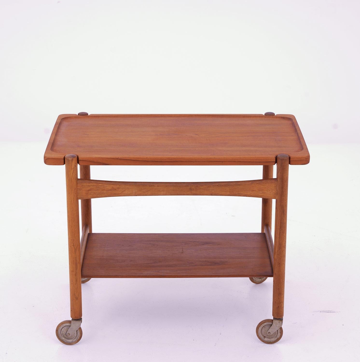 Beautiful design and well matched materials make this piece a good fit in a modern home. It consists of a solid teak top board, resting on an oak frame.

Condition: The table top has been sanded down and refinished, while the frame is just cleaned
