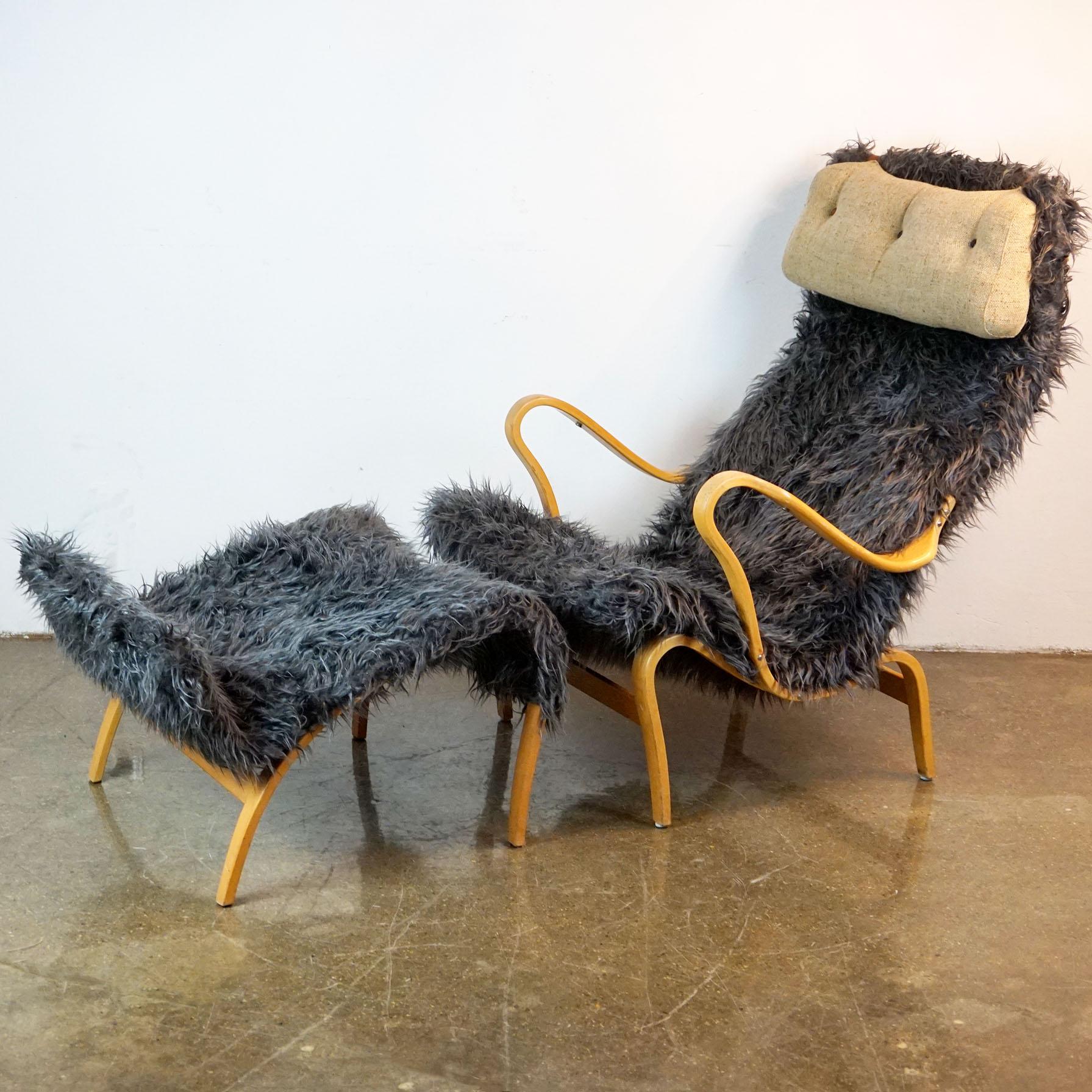 Very charming and comfortable organic lounge chair with its matching ottoman designed in the 1940s by Bruno Mathsson for DUX, Sweden. The set features a beechwood frame with grey fake fur upholstery, both parts are signed with manufacturers