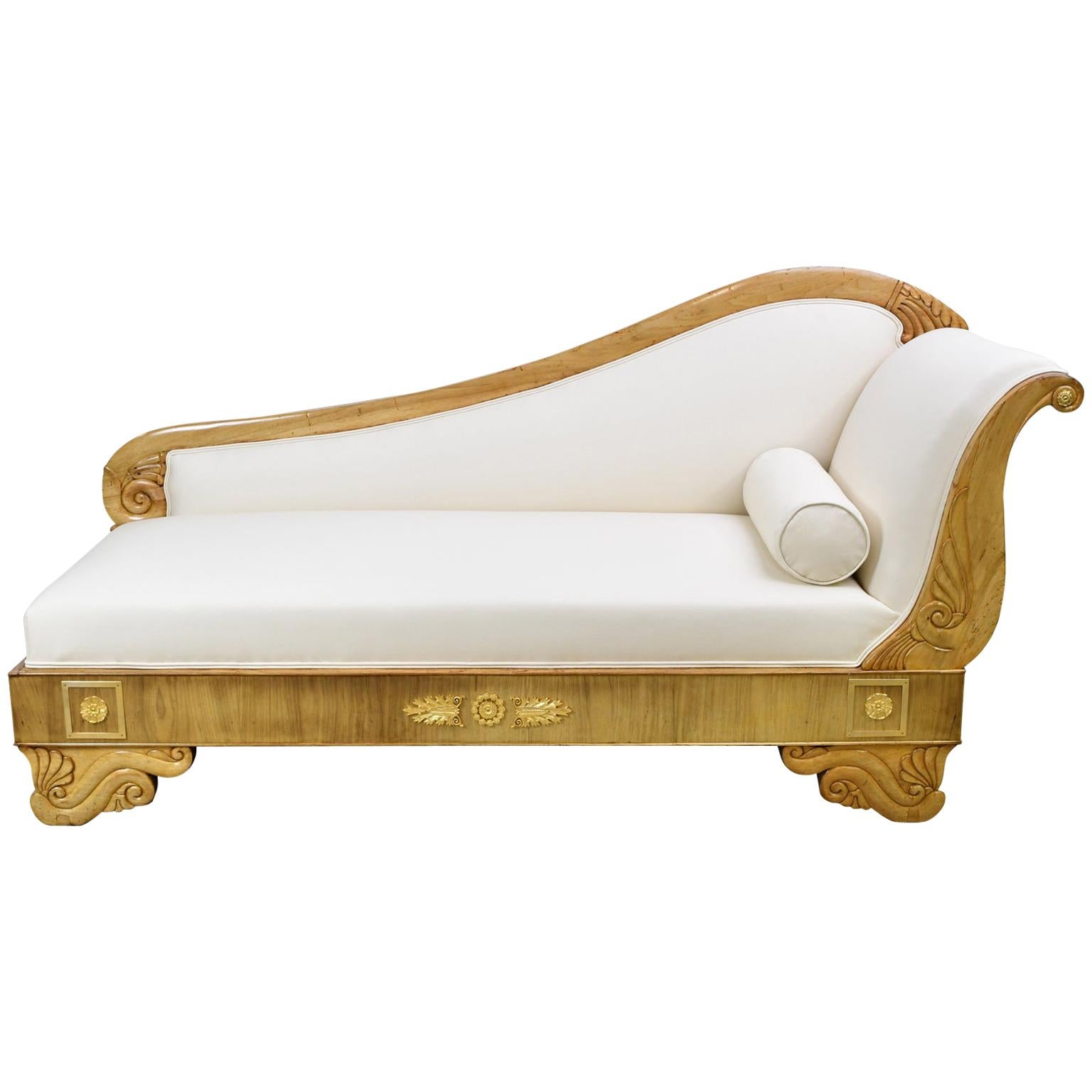 A Biedermeier Recamier or divan in light walnut with upholstery. Upholstered back starts low, rising to meet the scrolled side. Bronze d'ore ormolu mounts of foliate swags and rosettes decorate the bottom apron, Scandinavia, circa 1845.
This Divan