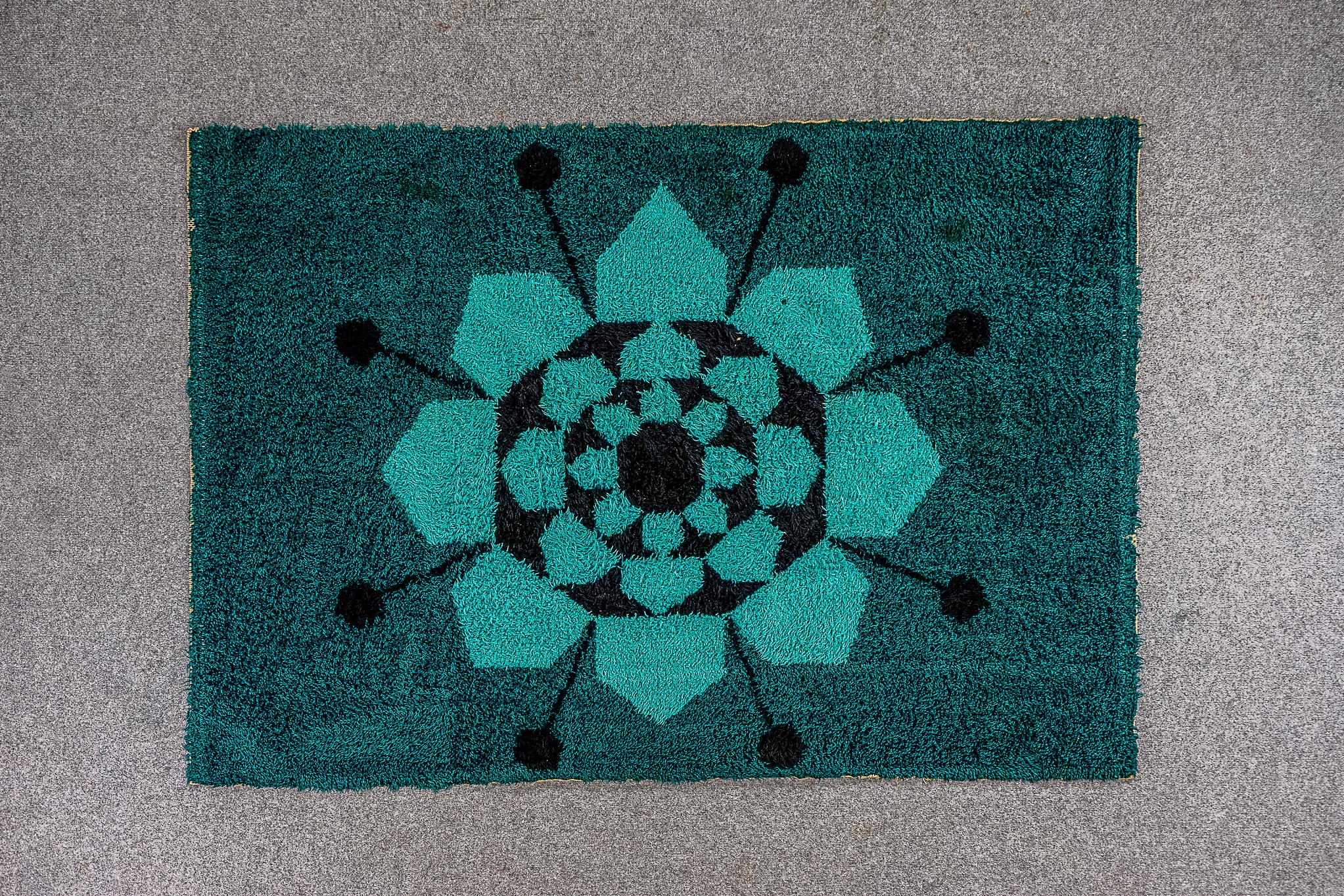 Wool Scandinavian rug, circa 1960's. Stunning geometric flora design in a cool aqua and teal colour scheme with black accents. Decent vintage condition, signs of wear on the edges and a few small stains.