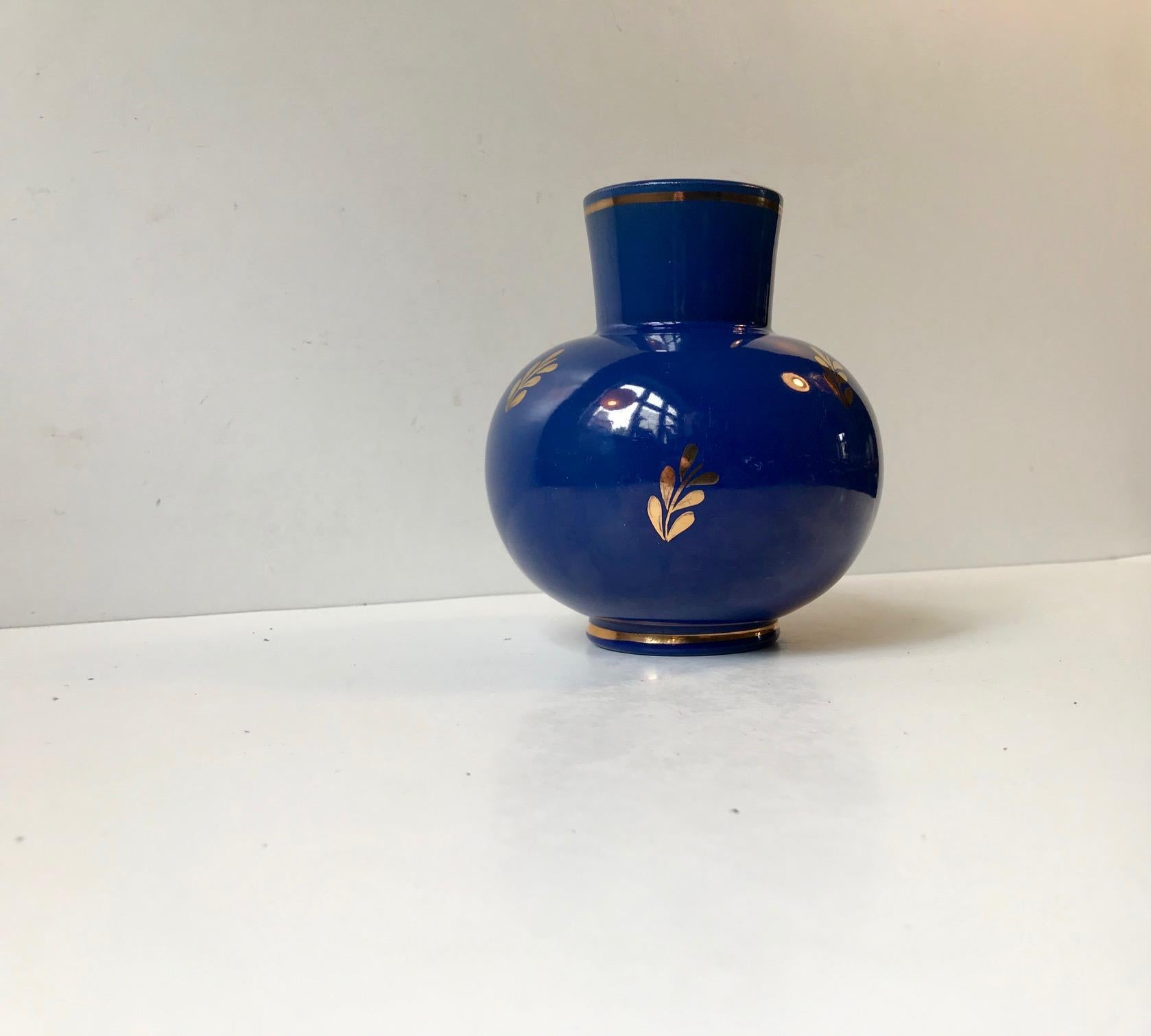 Swedish pottery vase manufactured by Nittsjo in Sweden during the 1940s. This series with applied gold leaf foliage on a blue main glaze was designed by Jerk Werkmaster. The vase is numbered and signed to the base.
  