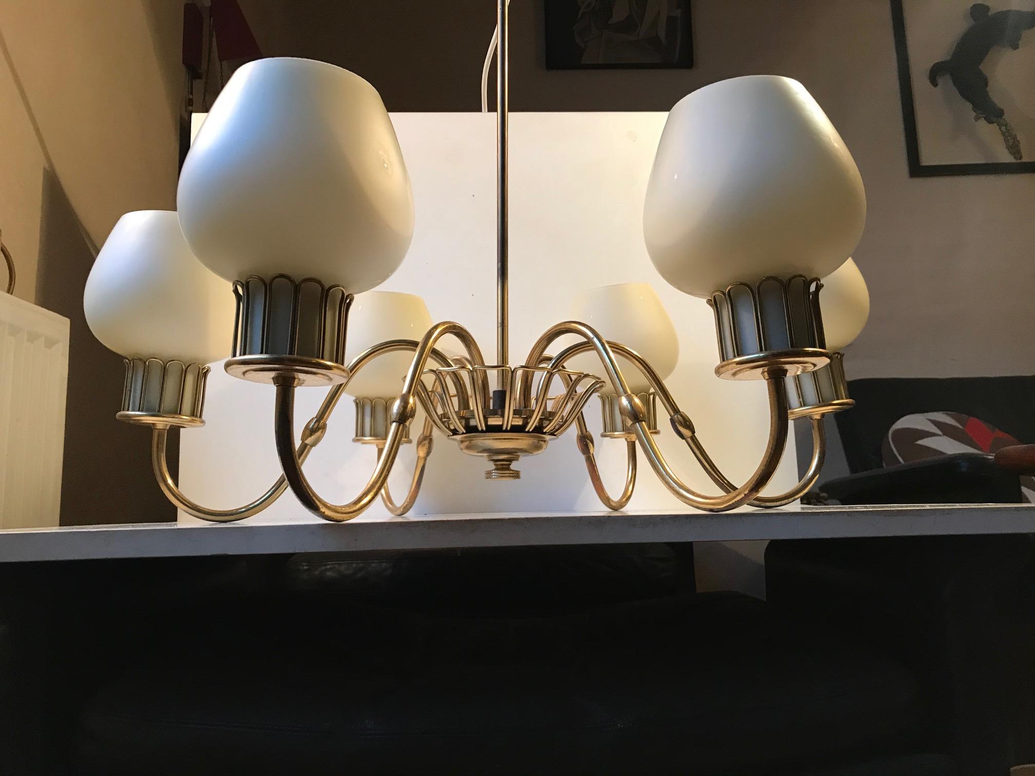 Spider construction in brass with six arms creamy white cased opaline glass shades. This design dating from the late 1940s or early 1950s is attributed to Josef Frank. It has E27 sockets and original ceiling spacer and canopy.