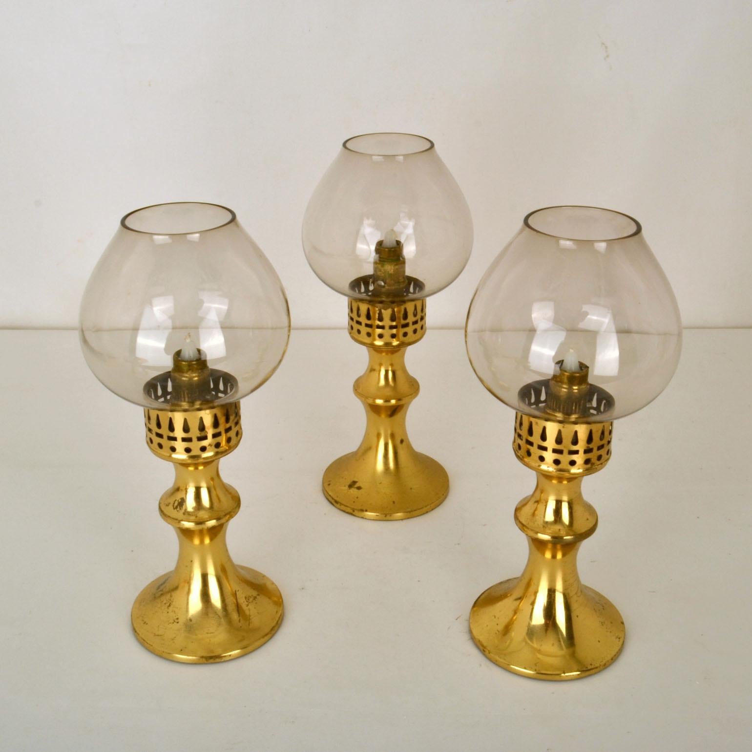 Set of three brass lantern candle holders with tinted glass diffusers, Scandinavian Modern 1960's. They are suitable for indoor and outdoor use.
They have a clever internal push up spring system for the candles so that it looks like they are oil