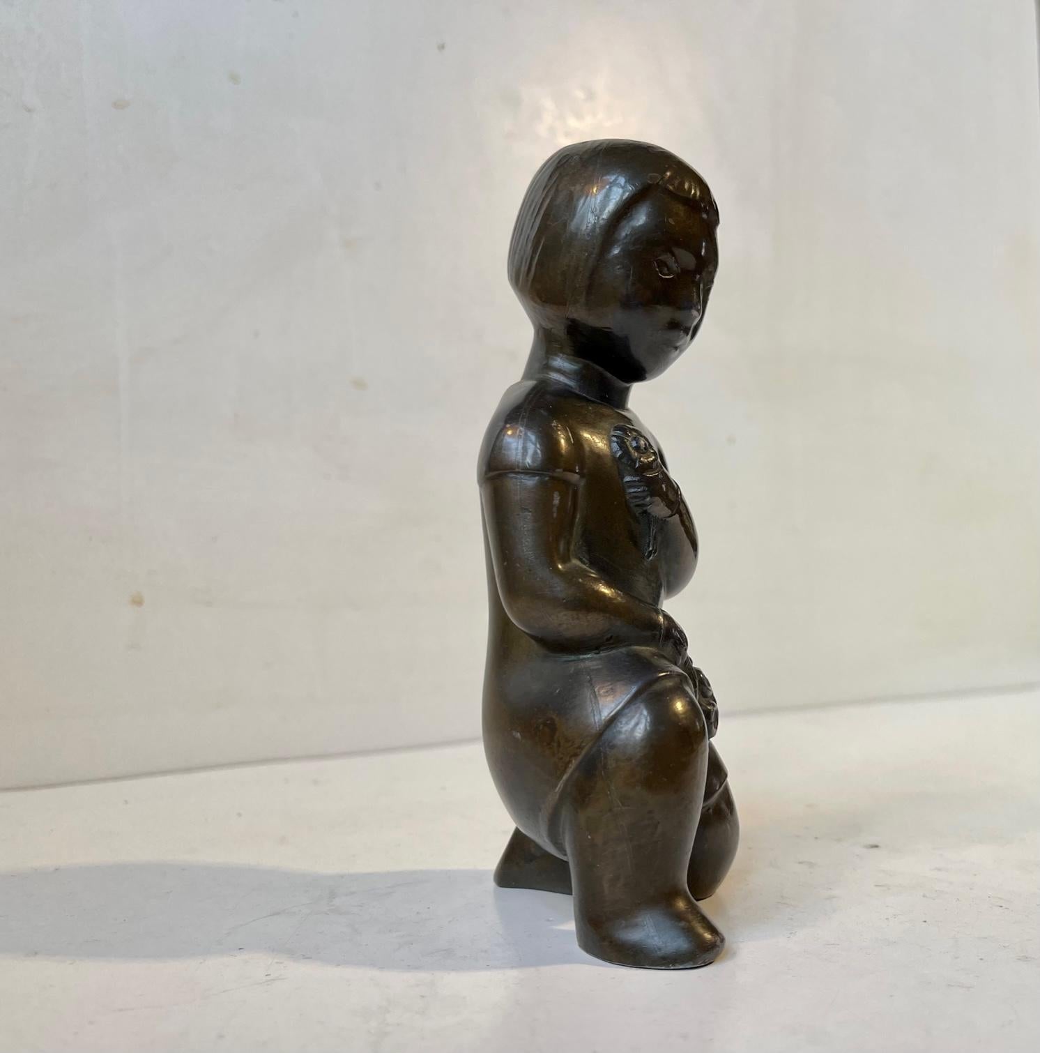 Small stylized bronze sculpture depicting young Inuit girl collecting flowers. Designed and studio cast in Scandinavia in a style reminiscent of Karl Josef Hoffmann and Just Andersen. It has no signature or markings. Measurements: H: 15, D: 6, W: 6