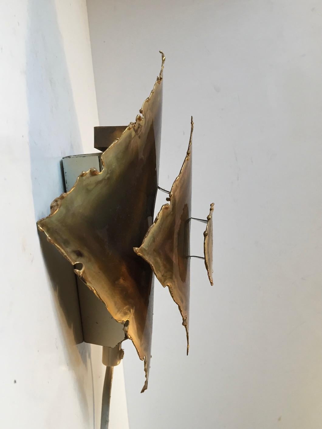 Torch cut, acid treated and patinated wall sconce manufactured by Holm-Sorensen Belysning in Copenhagen, circa 1960. Measurements: H 7.25, W 5.75 inches. Condition: very good.