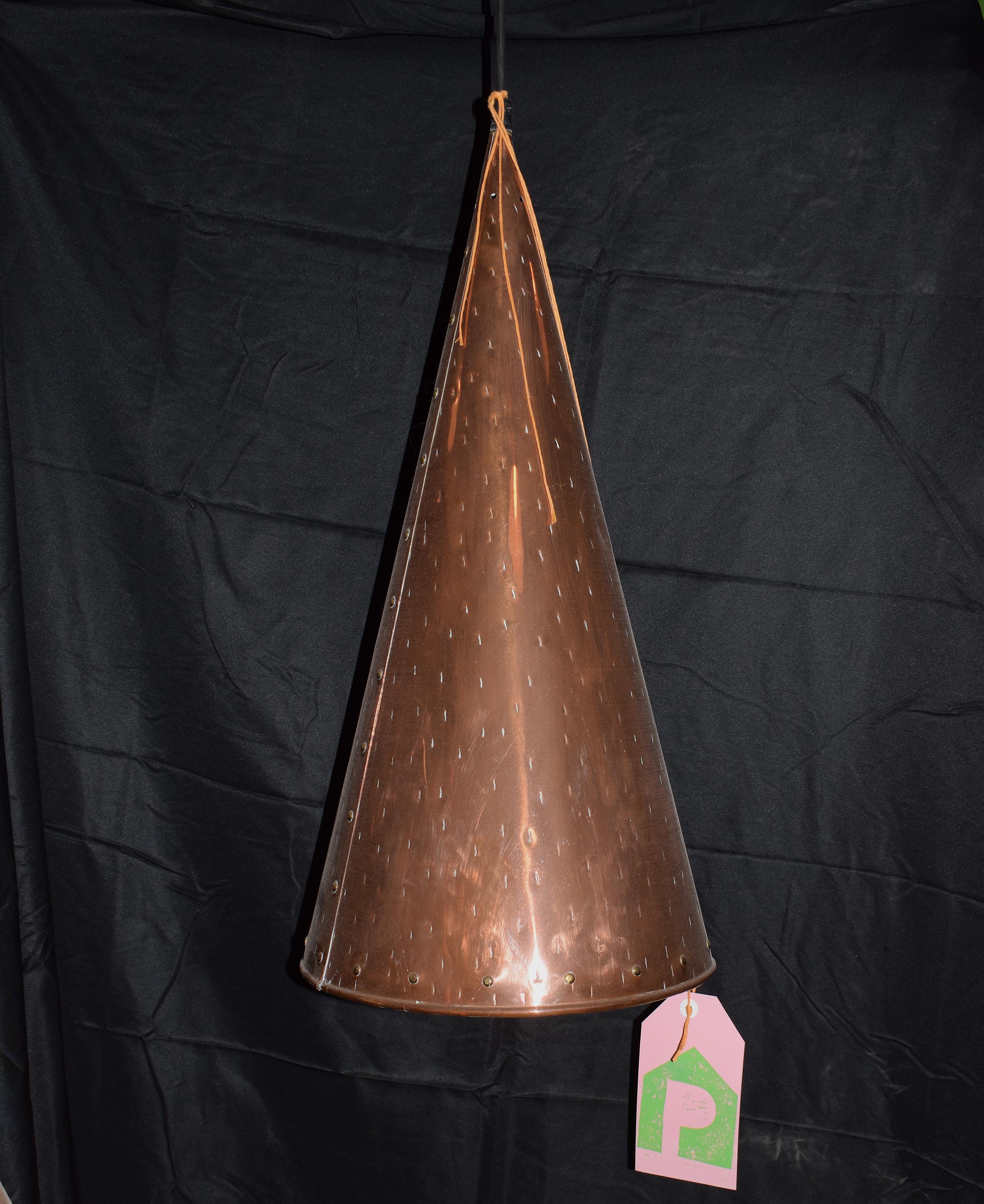 A large copper cone handcrafted pendant light. It is conical shape and in the material copper. The lamp was made by the company The Valentiner in Copenhagen by E.S. Horn Aalestrup during the 1960s. This ceiling pendant has brass rivet detail with a