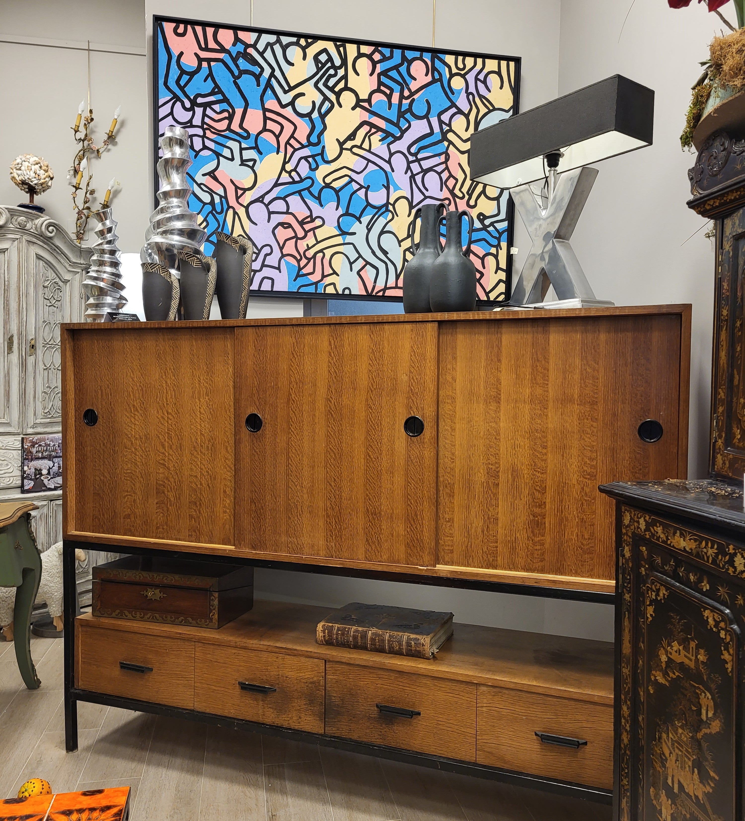This  Gorgeous cabinet is a testament to Scandinavian ingenuity and craftsmanship, with an upper body housing three sliding drawers with circular handles, providing refined organizational space for the most delicate objects. The lower body has four