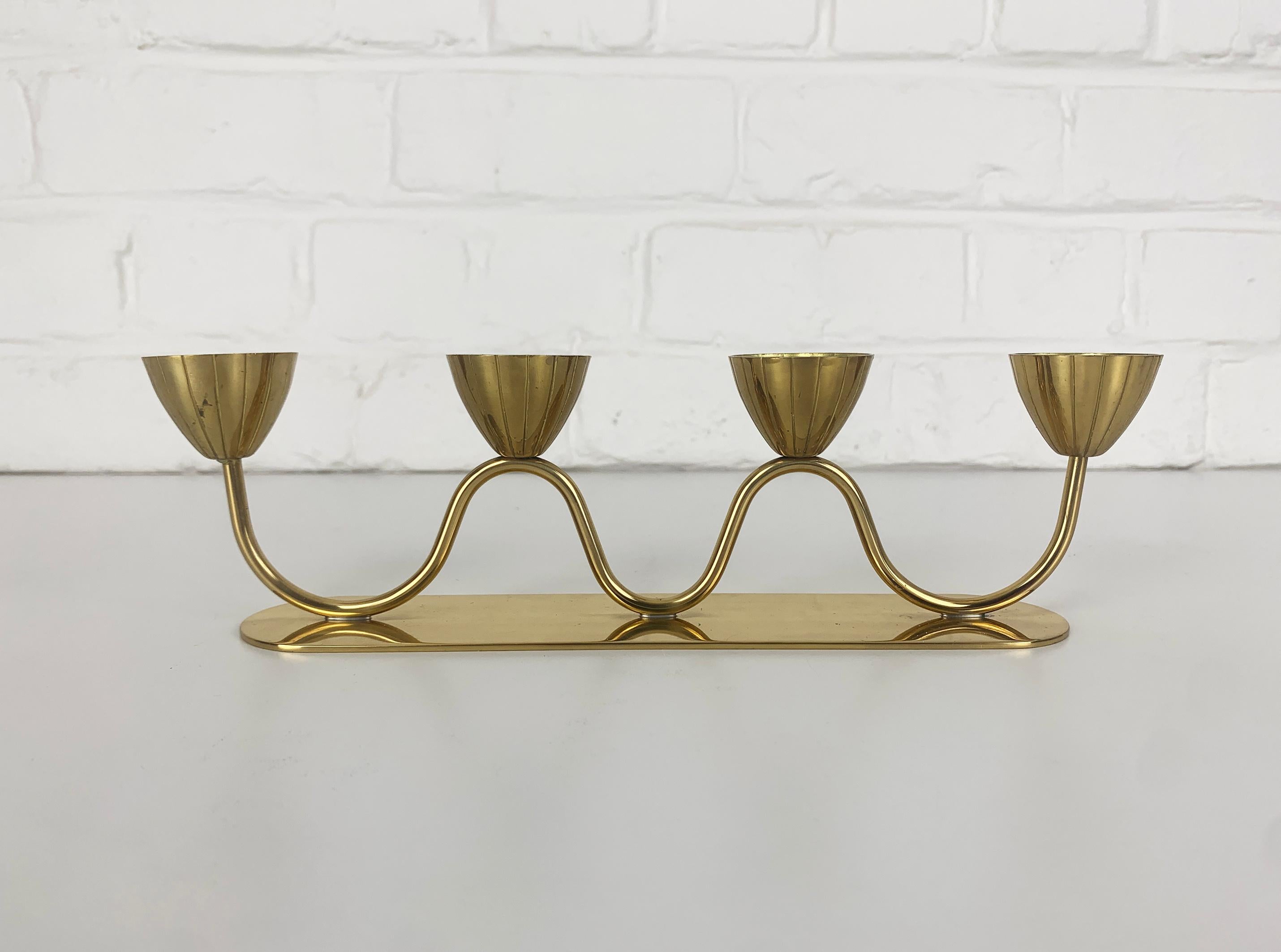 Candelabro modernista svedese di Gunnar Ander. Prodotto da Ystad-Metall, con sede nella città di Ystad in Svezia. 

Portacandele in ottone massiccio e lucido. Design organico di quattro fiori stilizzati che sono posizionati su uno stelo a forma di