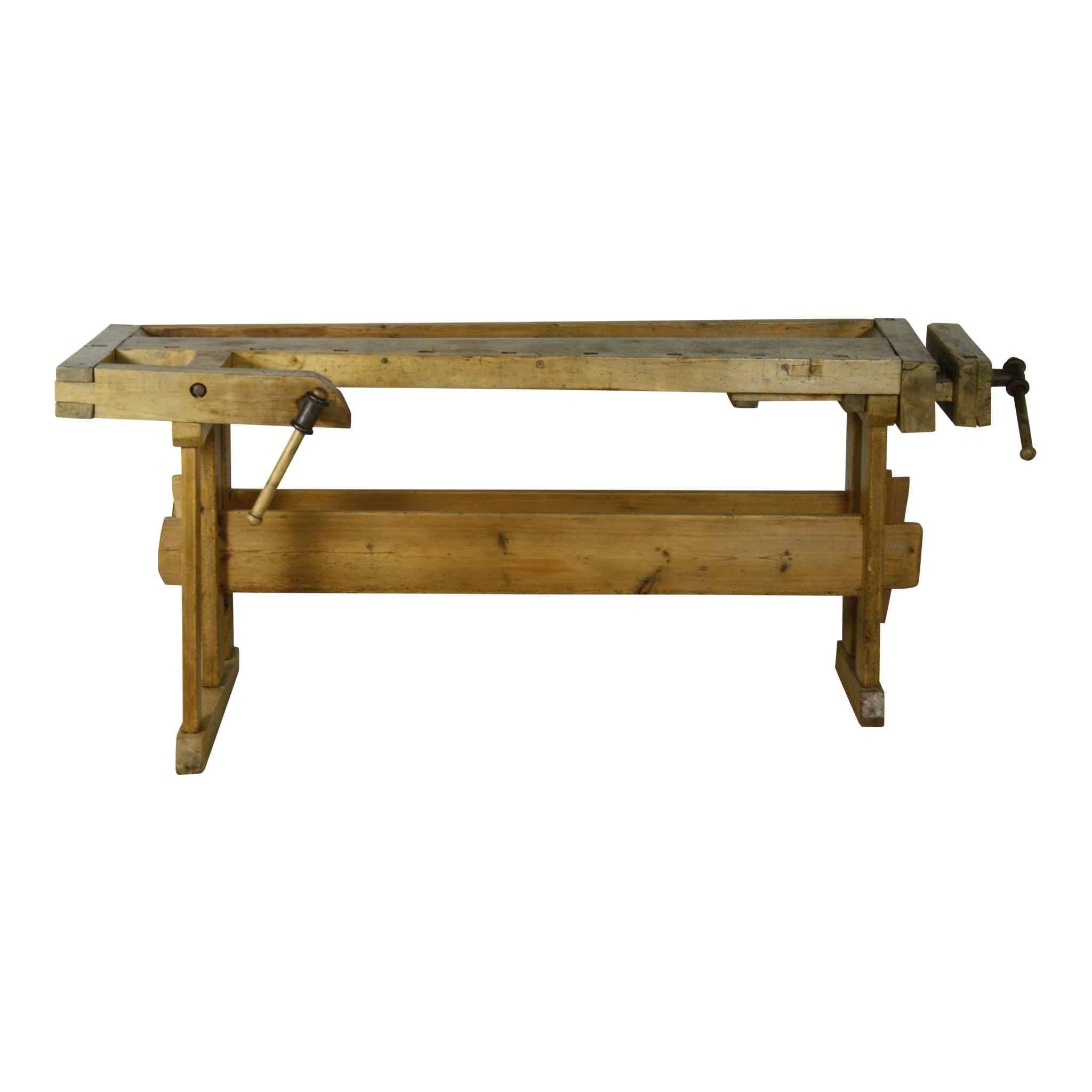 Designed for a woodworking craftsman, this pine workbench has two vises: one on the front or face and another on the end or tail. The left side position of the end vise and the right side position of the face vise suggest that this bench was created