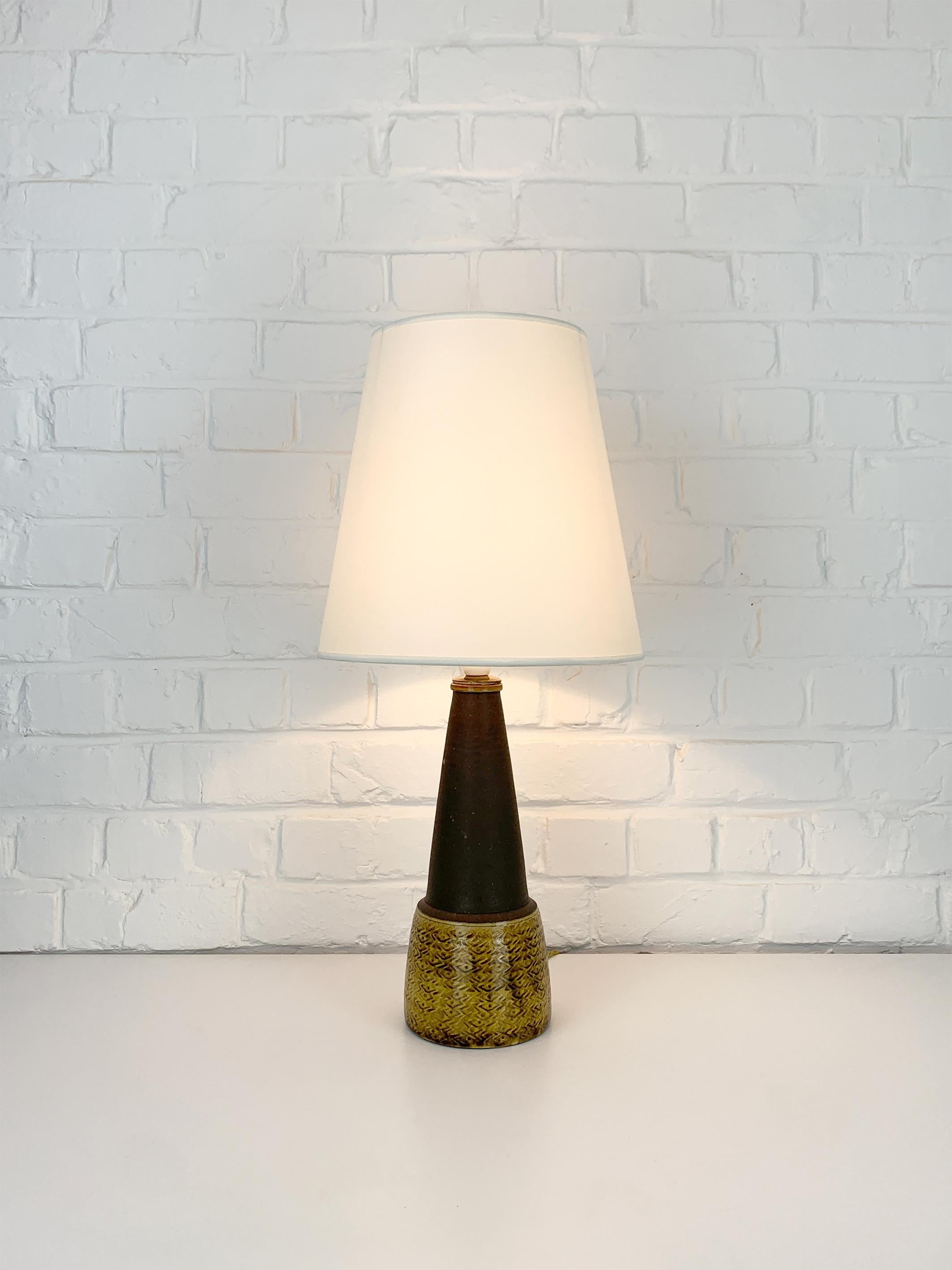 Stoneware table lamp in brown and uranium yellow glaze, designed by Nils Kähler in the 1960s. Manufactured by the workshop of Herman A. Kähler Ceramic (HAK) in the town of Naestved in southern Denmark.
Nils Kähler was the fourth generation of the