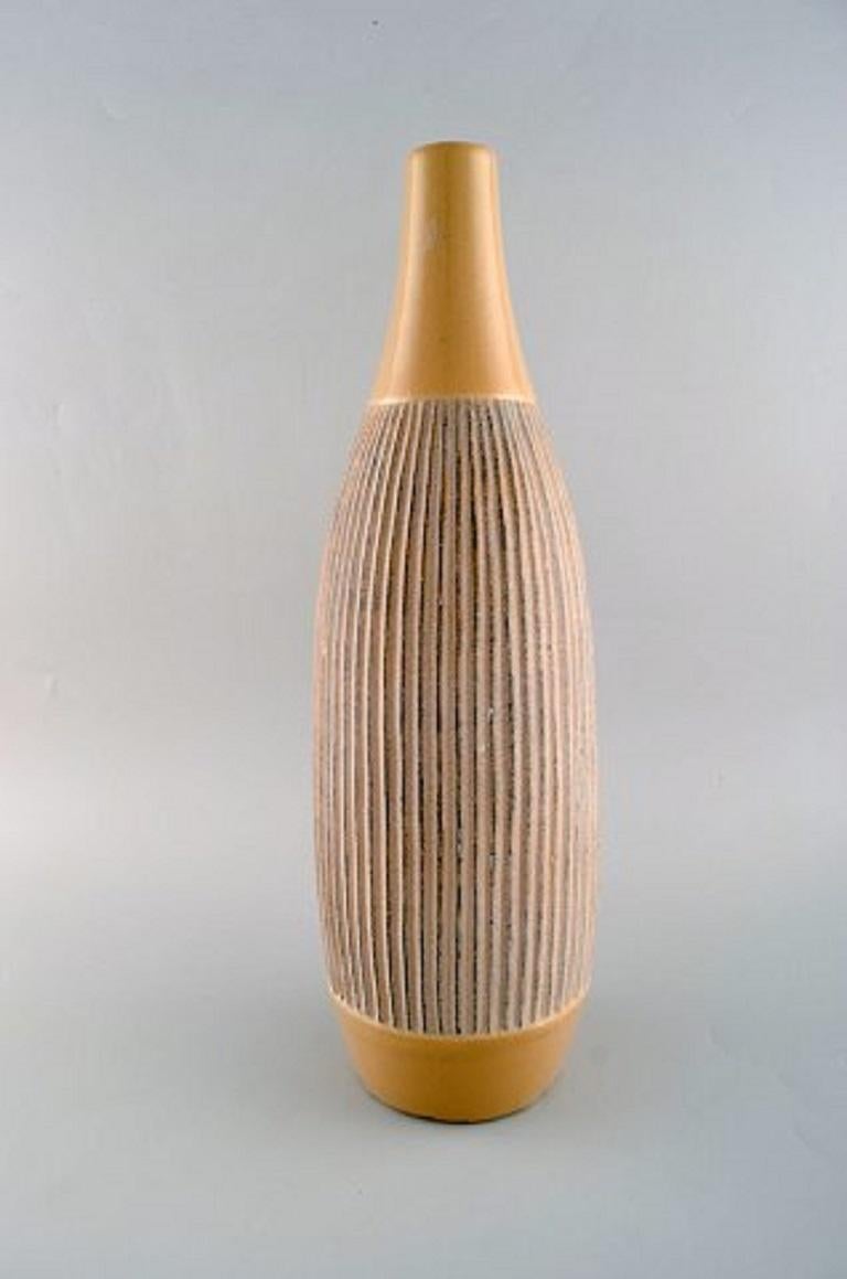 Skandinavischer Keramiker. Große Vase aus glasierter Keramik mit gerilltem Korpus, Ende 20. Jahrhundert.
Maße: 45 x 14 cm.
In gutem Zustand mit kleinen Chips auf der Unterseite aus der Produktion.