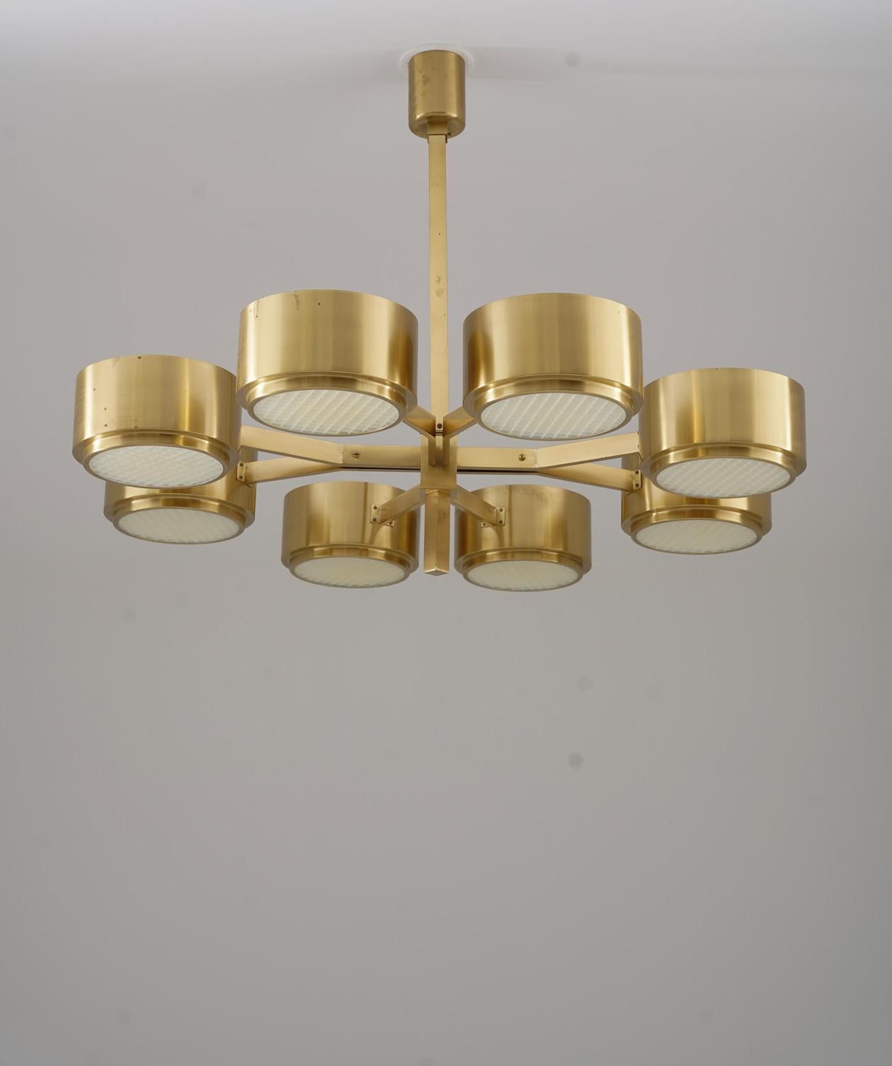 Rare vintage chandelier designed by Hans-Agne Jakobsson, model T 493/8. This striking ceiling light features eight circular brass shades arranged in a refined, radial composition. Each drum-shaped shade is fitted with a perforated diffuser grid that