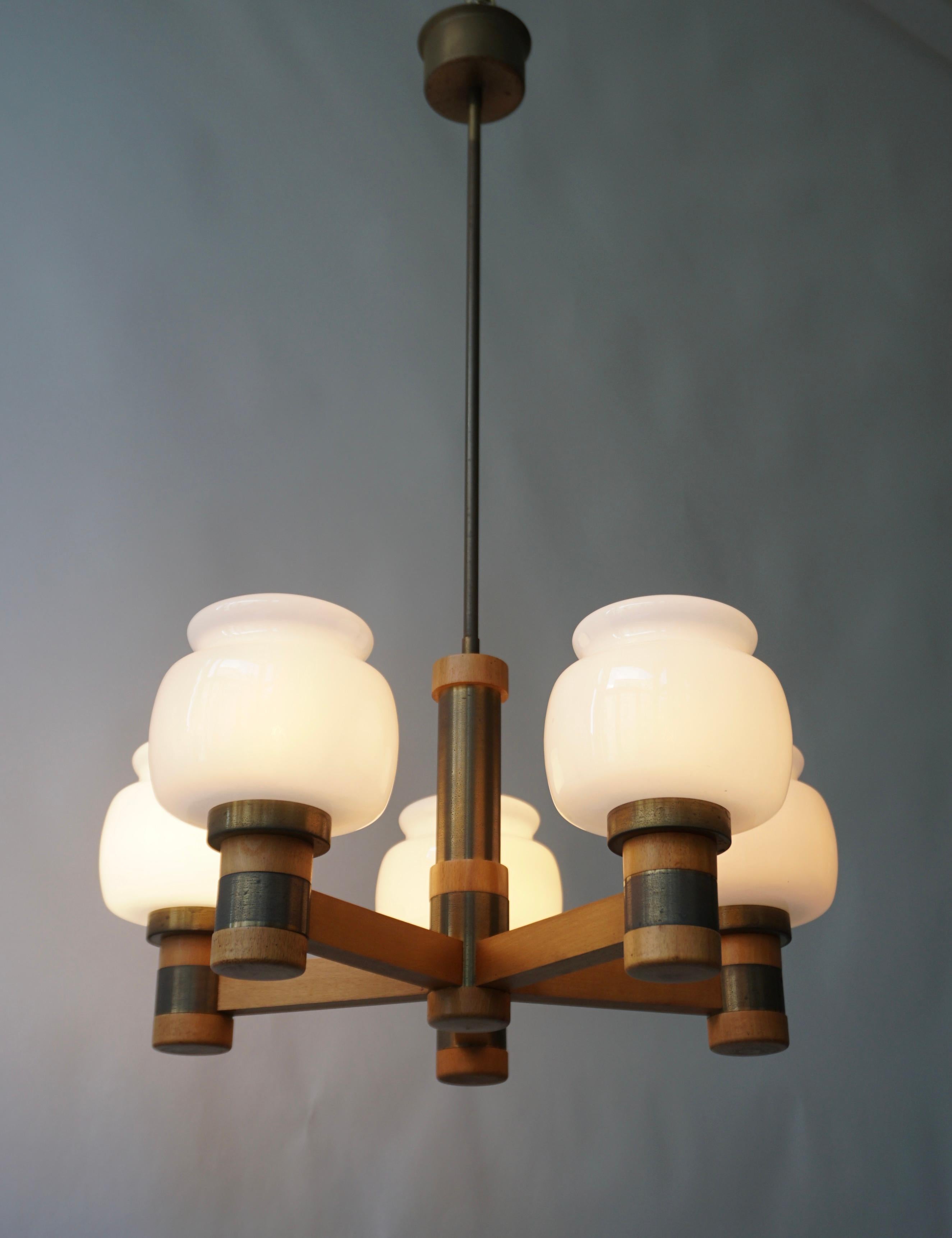 Scandinavian pendant light in wood and brass with 5 with opaline shades , 1960.

Diameter 50 cm.
Height 80 cm.
Height fixture 24 cm.
The light requires five single E14 screw fit lightbulbs (45 Watt max.) LED compatible.
