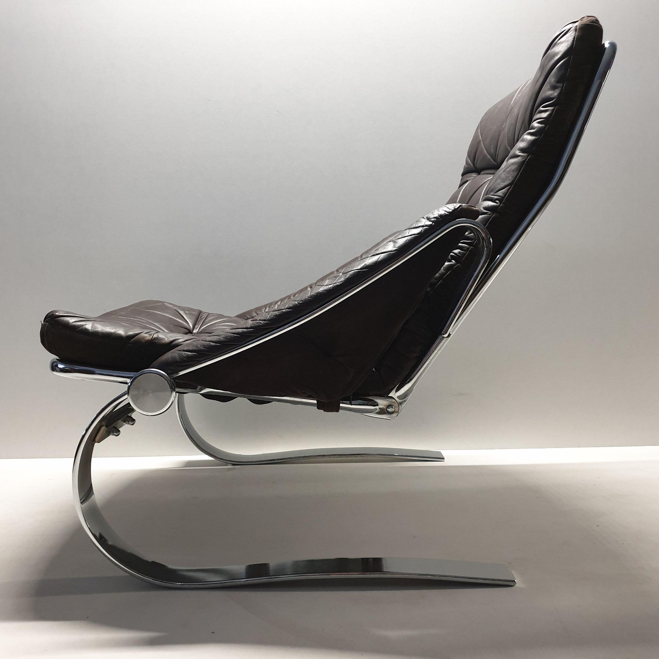 Scandinavian chrome flat steel and leather lounge chair with an adjustable backrest.

Comfortable heavy armchair with a chromed spring steel frame and the original brown leather upholstery.
The back of the upholstery is velvet.
The position of