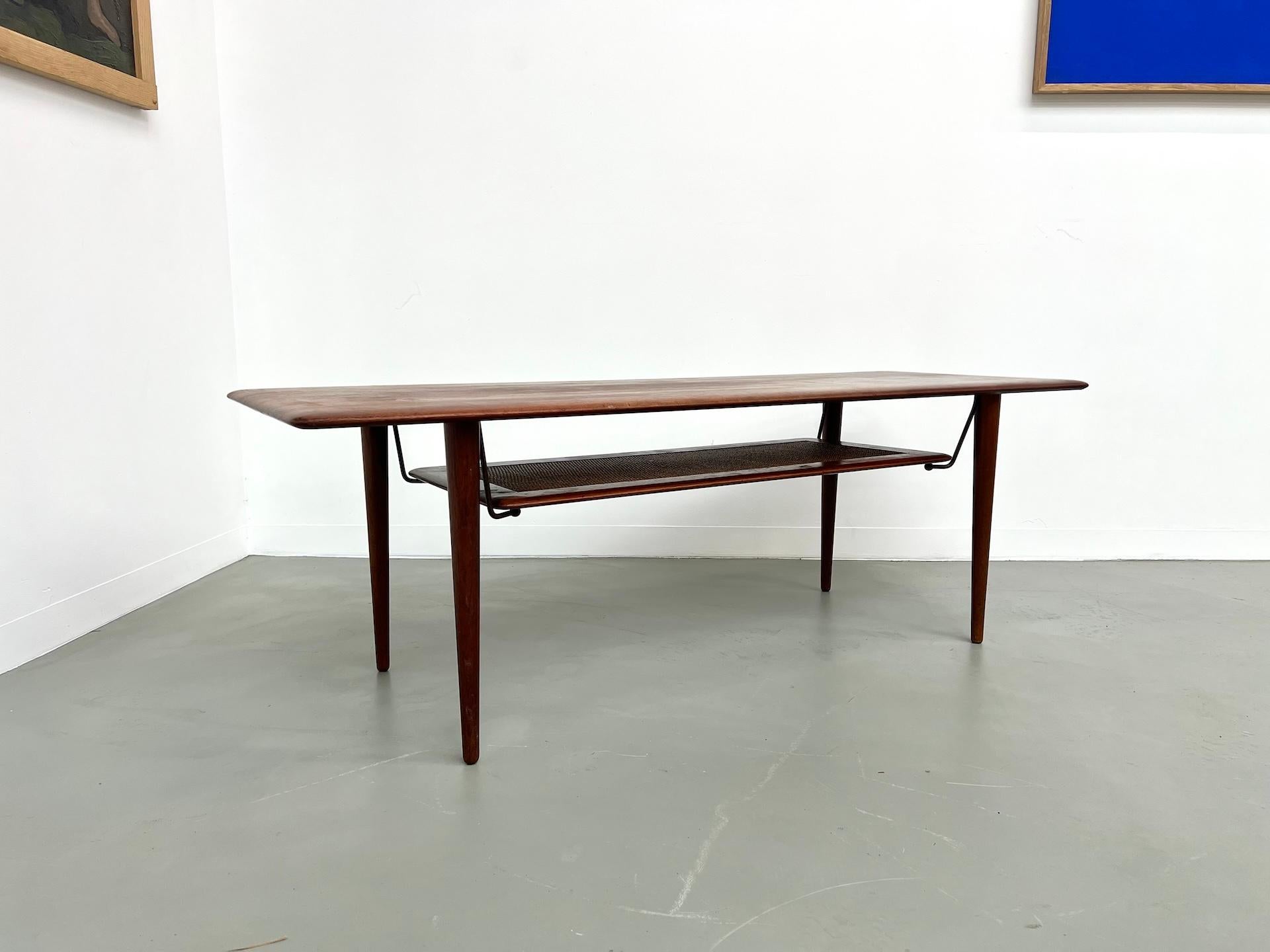 Maison Lecan presents this rare 1960s coffee table designed by Peter Hvidt & Orla Mølgaard-Nielsen for France & Daverkosen. Rare model FD-516. The frame and tabletop are made of solid teak, with an additional rattan top supported by brass