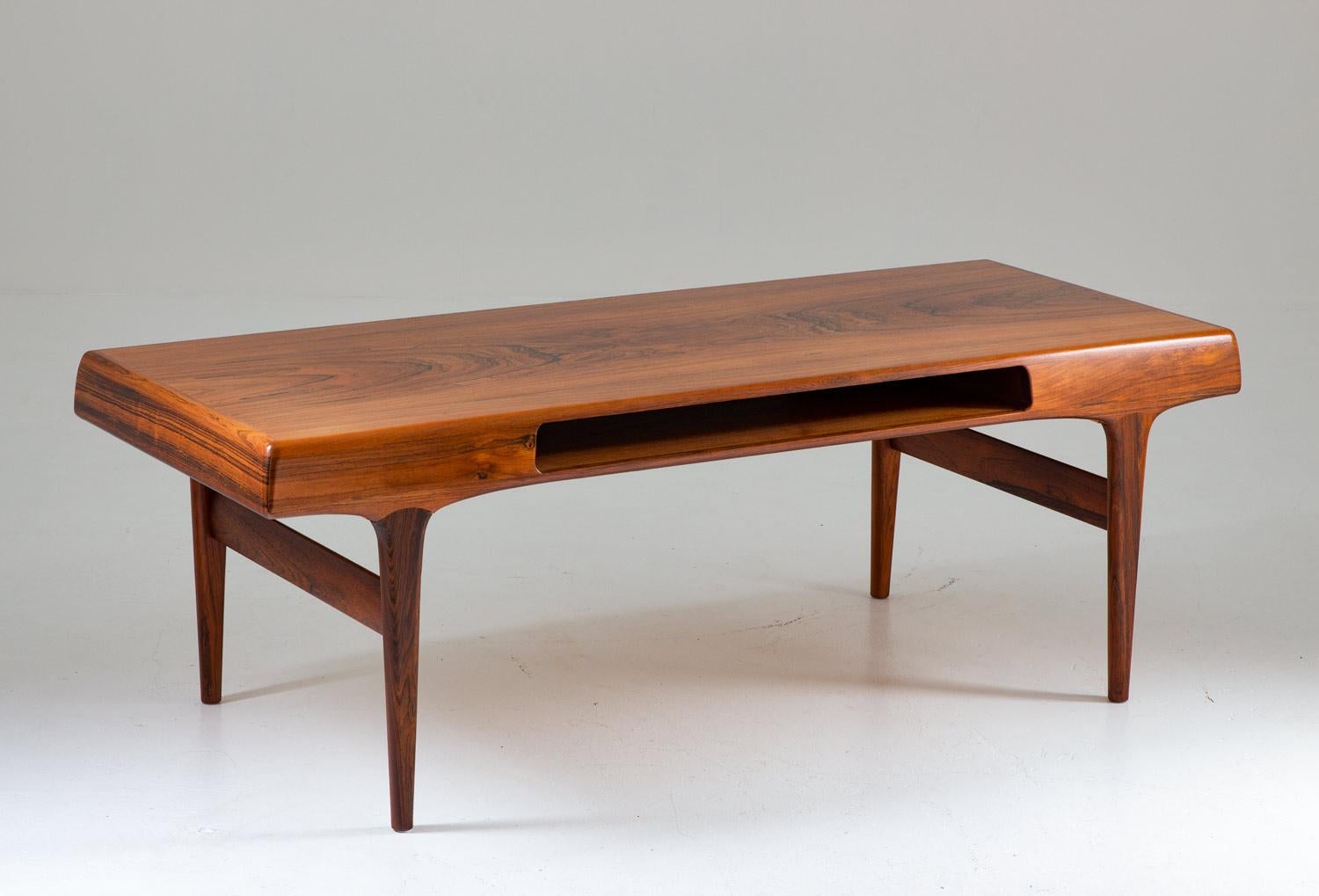 Table basse en bois de rose de Johannes Andersen, années 1960. 
Belle table basse aux bords arrondis, typique des créations de Johannes Andersen. Cette table rectangulaire offre beaucoup d'espace pour les magazines et les petites choses avec deux