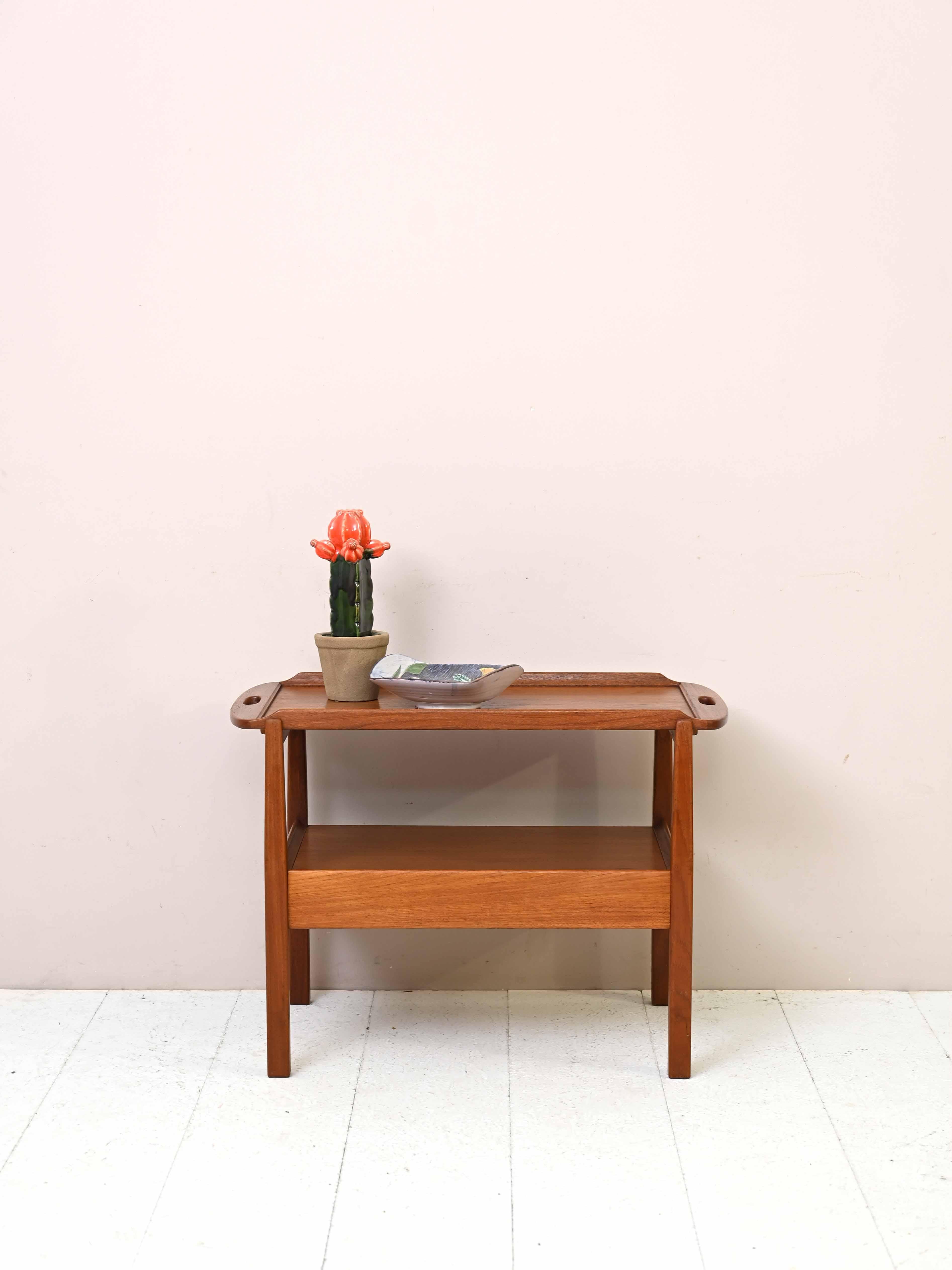 Vintage teak table with removable top.

A piece of furniture with a retro flavor that is distinguished by its distinctive tray-shaped top that can be detached from the frame.
It can be used as a side table, sofa table or as an additional support