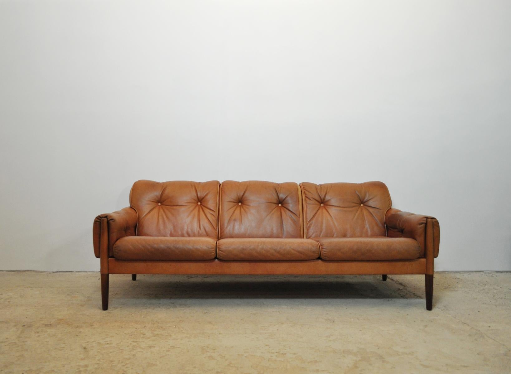 Scandinavian cognac brown leather and rosewood 3-seater sofa.
Probably Danish from 1960s. Good vintage condition. 
Patinated with signs of wear consistent with age and use.

Also a set of 2 Lounge Chairs - see the last picture and search for item