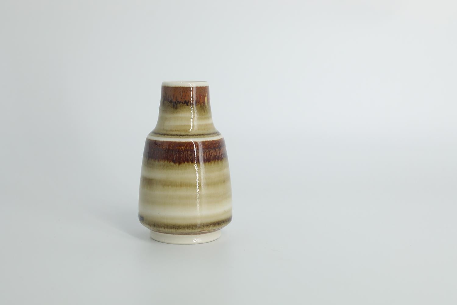 This miniature, collectible stoneware vase was designed by Gunnar Borg for the Swedish manufacture Höganäs Keramik during the 1960s. Handmade by a Master, with the utmost care and attention to details. The vase is colored in irregular shades of