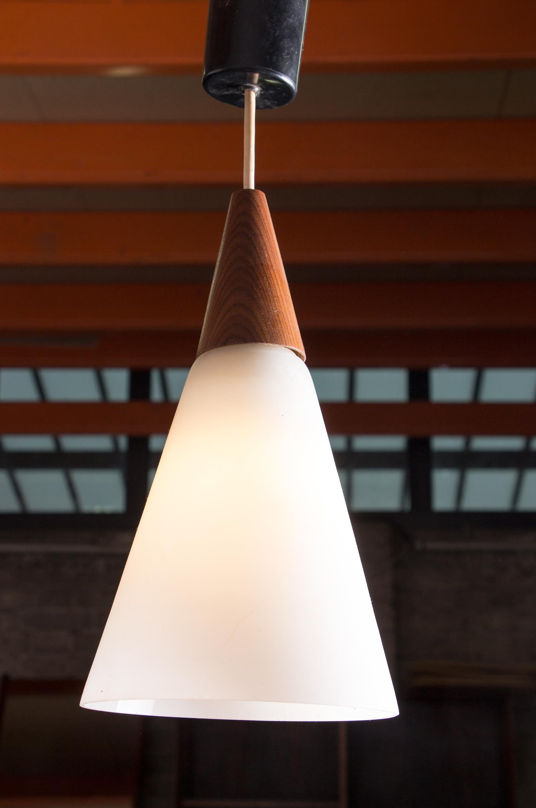 Scandinavian conical pendant light in teak and Opaline by Louis Kalff. 1