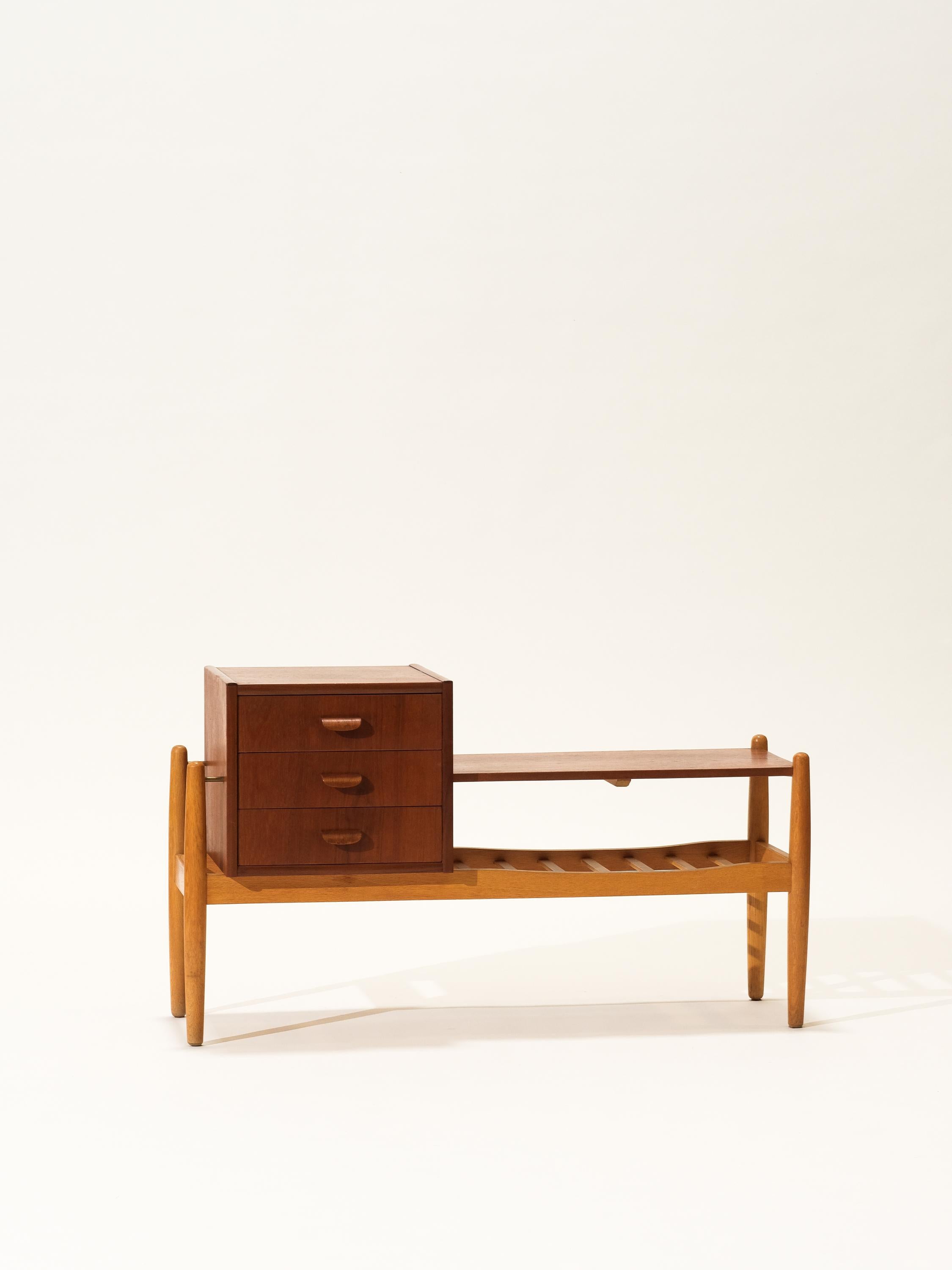 Small side or console table with a rack, a shelf and three drawers. Made of veneered teak and oak. Round tapered legs and brass details. Designed by Arne Wahl Iversen for Ikea. Great piece for the entrance or hallway.