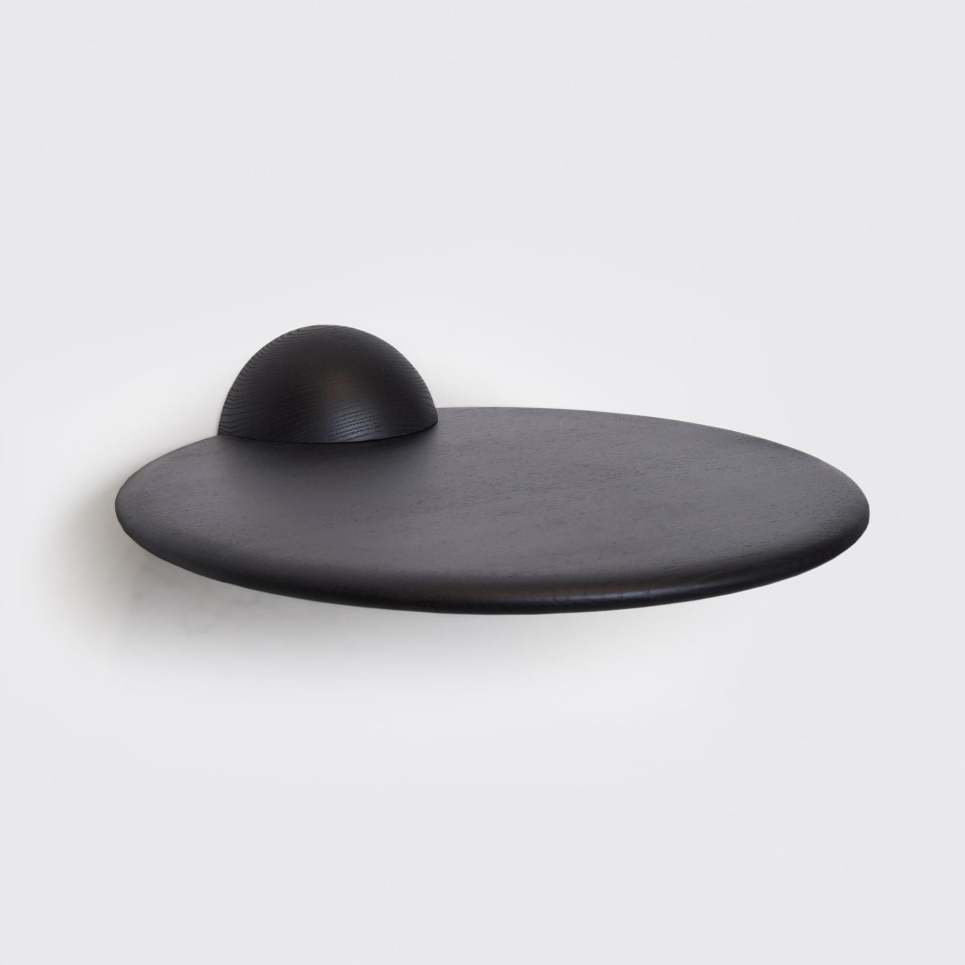The half sphere holding the plane contributes to a bold yet minimal look that works well in several different spaces and environments. Whether used as a shelf for an extraordinary object, as a bedside table or as a small bar table it's present with