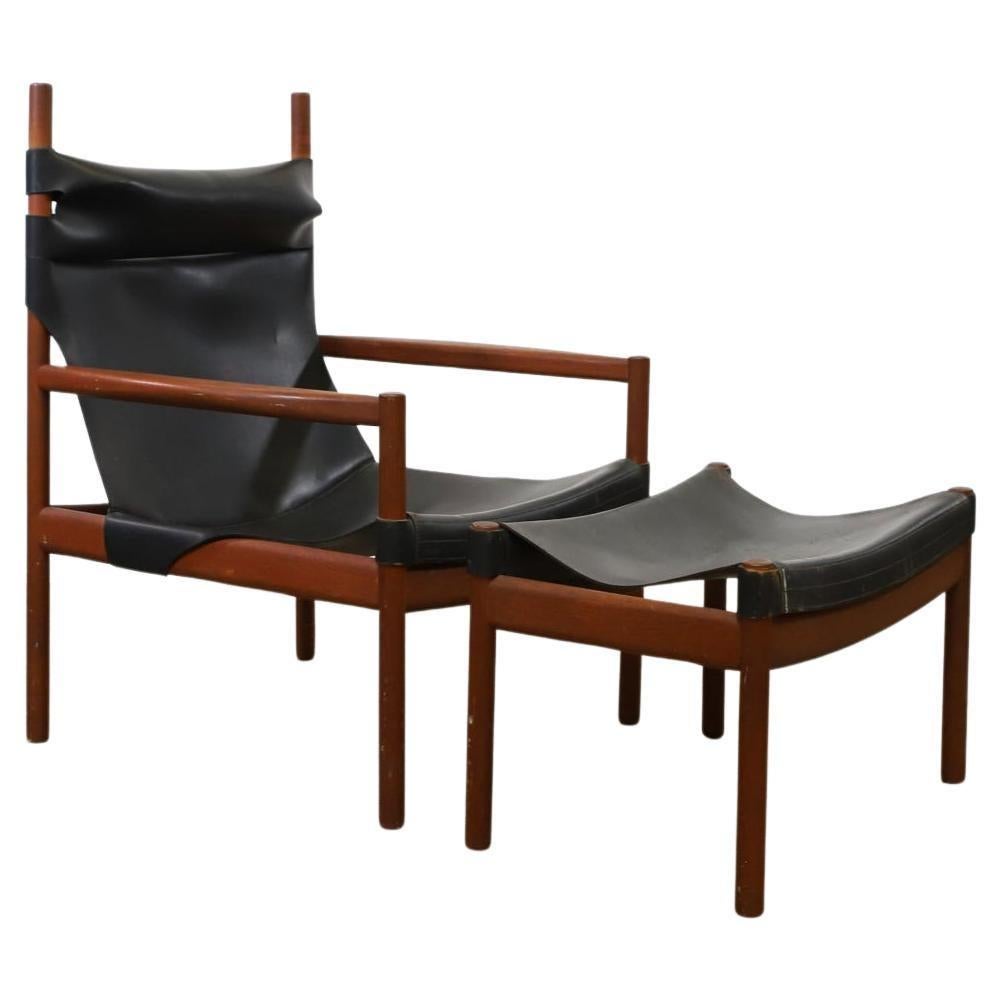 Sedia safari modernista scandinava con struttura in teak con braccioli scolpiti, barelle dritte e arrotondate e supporti rotondi. Ha una spessa seduta a fionda in pelle nera e un pouf abbinato. Prodotto in Danimarca. 

Sedia 37