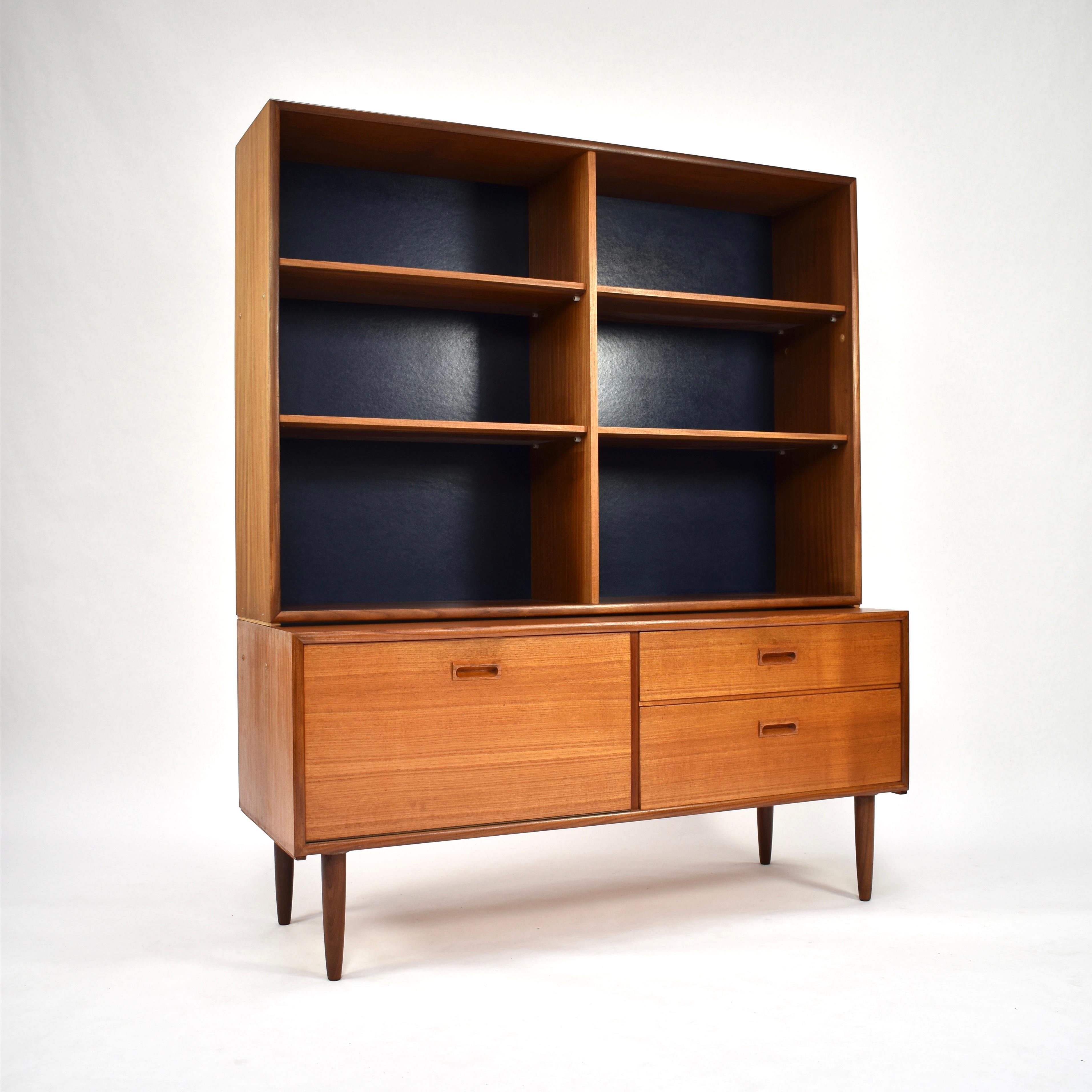 Danish bookcase cabinet in teak with dark blue back (looks black in images).
The cabinet consists of two parts; sideboard and shelve part. So it can also be used seperate.

Designer: Unknown

Manufacturer: Unknown

Country: Denmark

Model:
