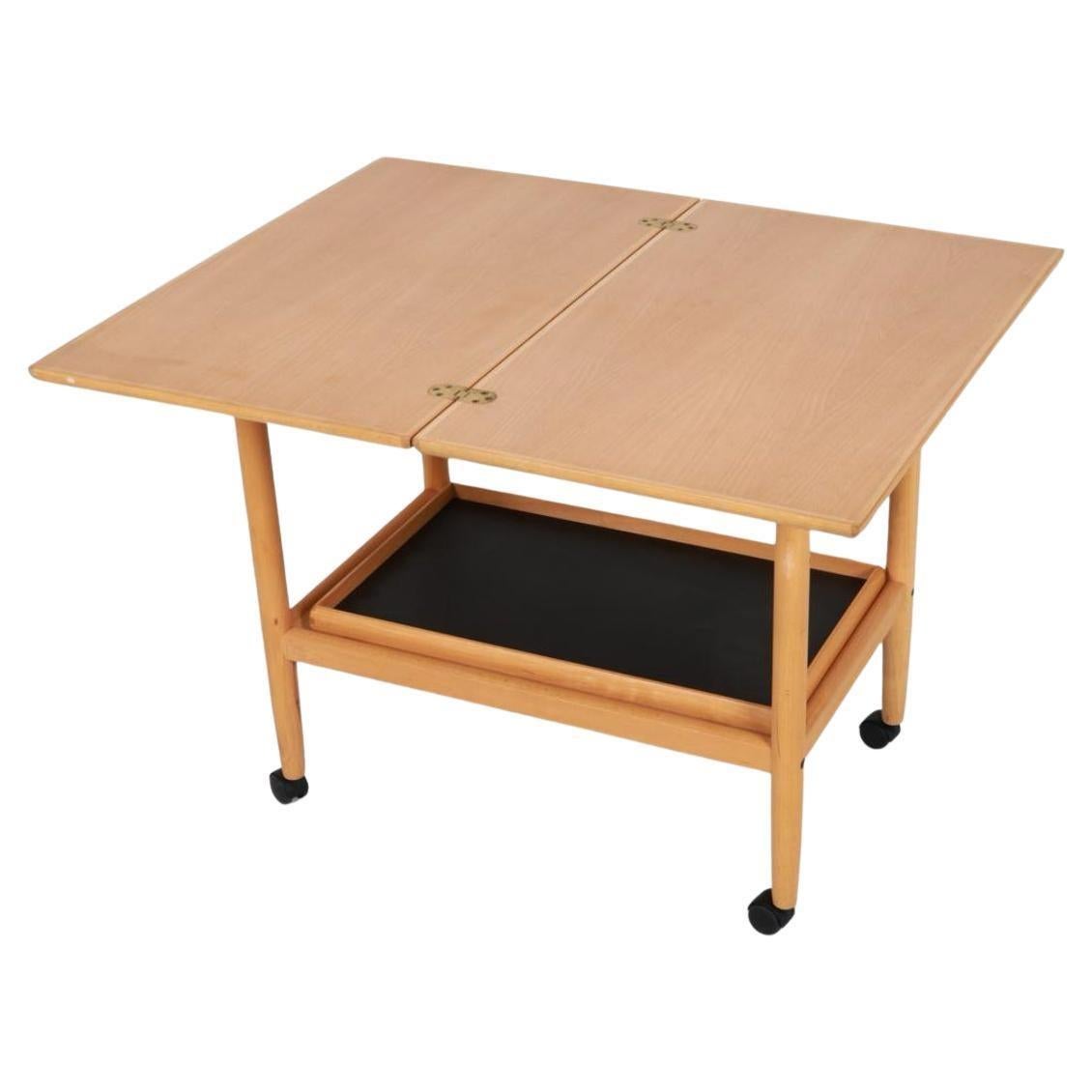 Simple Scandinavian Danish modern blonde beech bar cart server with flip top and a lower removable tray on casters. Solid beech wood top slides sideways flips and extends center top. Original vintage condition clean all around. Lower tray is