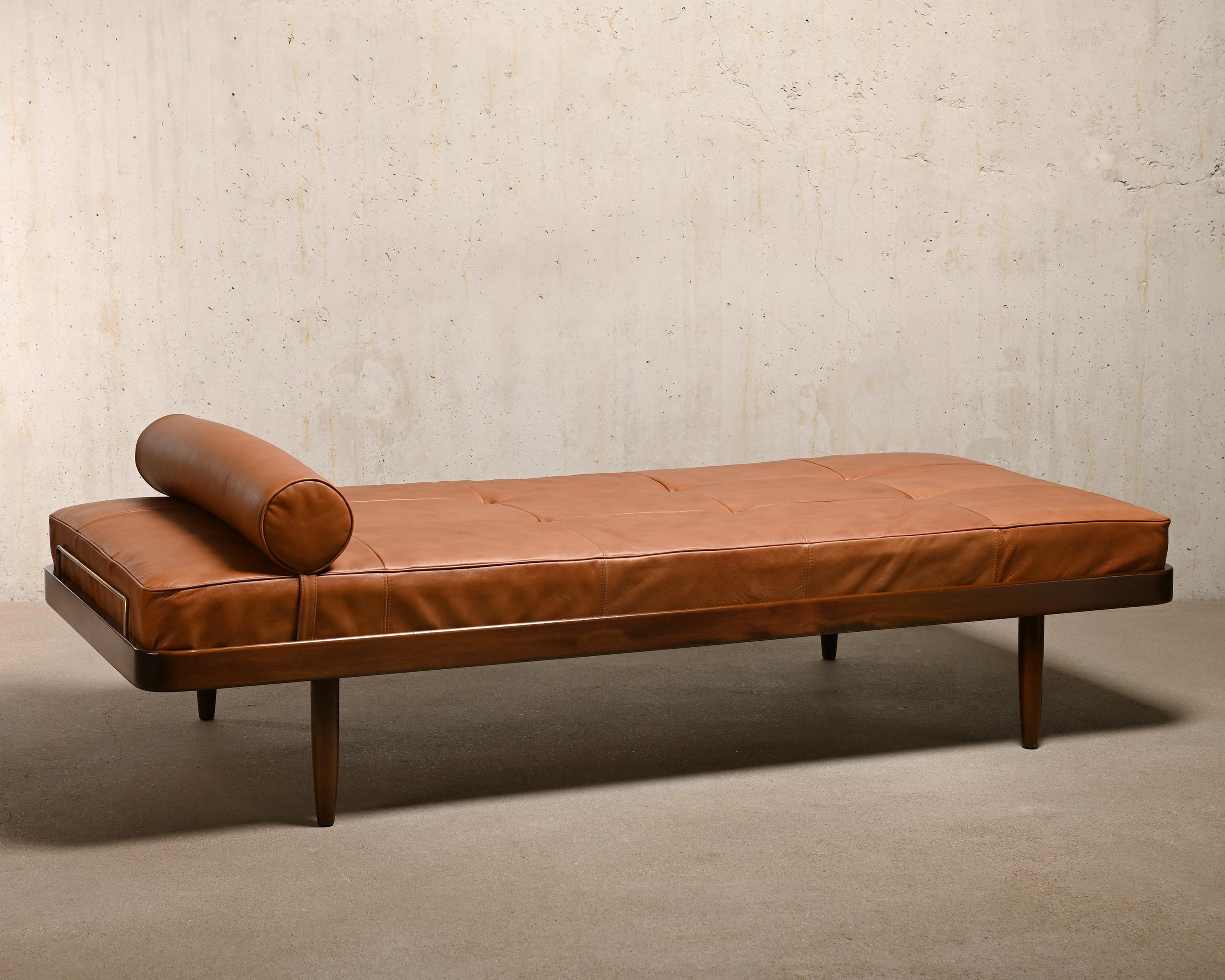 Scandinavian Daybed in Cognac leather manufactured by Horsens Møbelfabrik Denmark in the sixties. Dark stained wood in good condition with slight signs of use and ageing. The frame has nice details with rounded corners, brass brackets and tapered