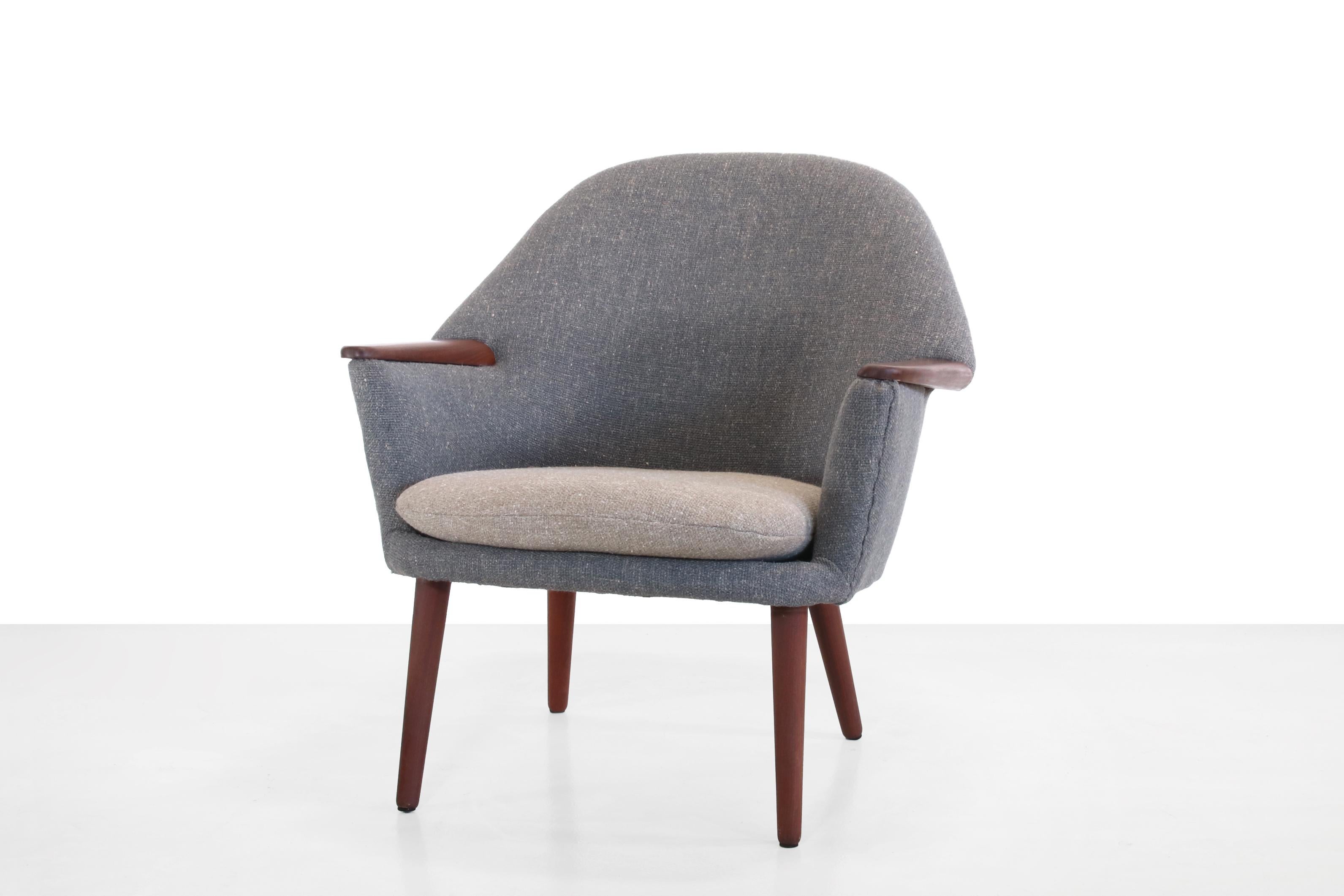 Magnifique fauteuil de design danois dans le style de Nanna Ditzel. Ce fauteuil a été retapissé en duotone dans un tissu de couleur bleu désaturé et gris chaud avec une belle structure grossière et possède des pieds et des accoudoirs en teck massif.