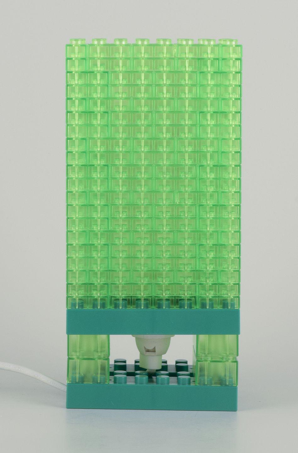 Pre-owned goods are exempt from import duties for U.S. customers. 
Therefore, no import tariffs will be applicable to your purchase.

Scandinavian design. Table lamp in green plastic.
Plastic blocks in Lego style.
Late 20th century.
Perfect