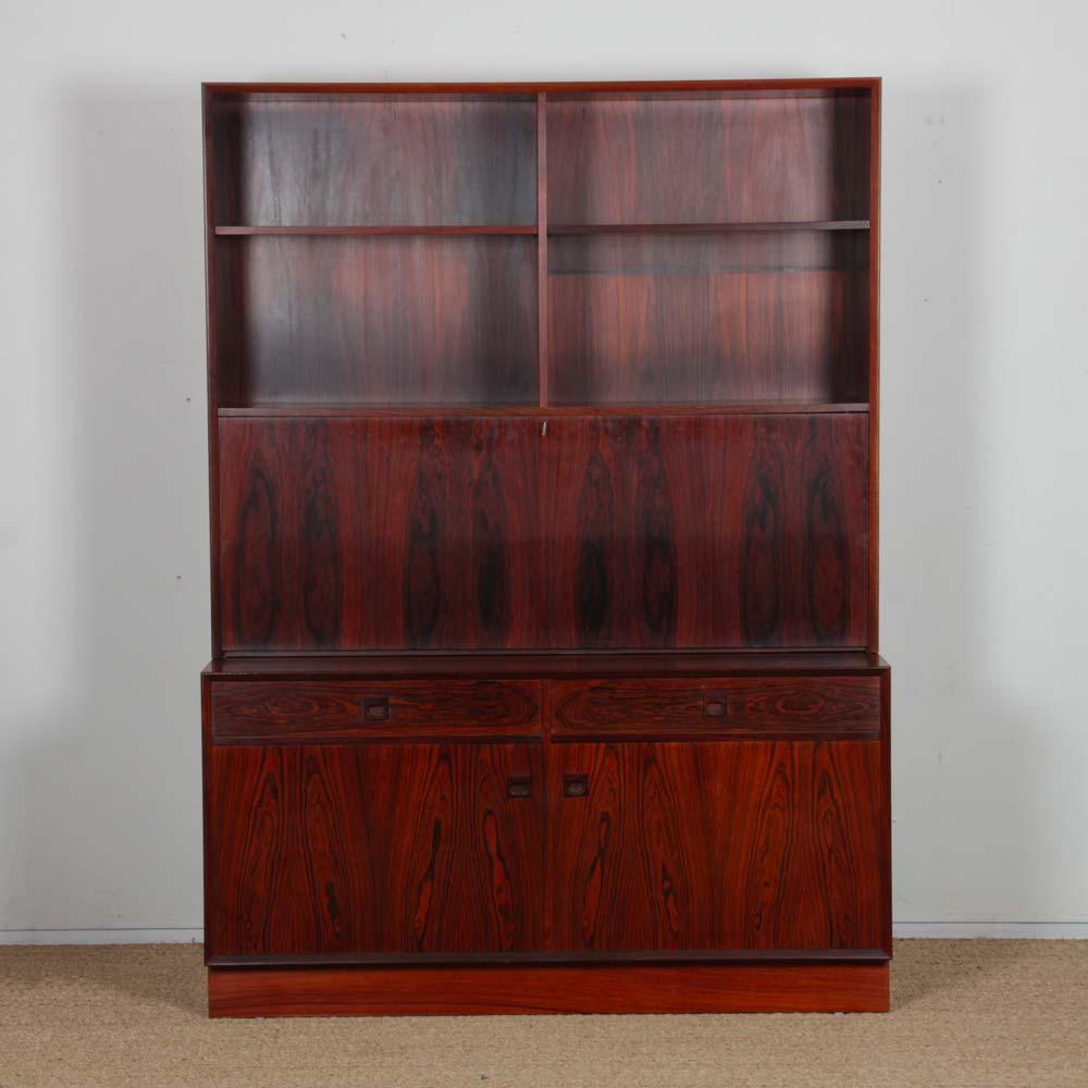 Questa segreteria scandinava è realizzata in legno di palissandro Rio. È stato progettato da Erik Brouer per l'editore Brouer Mobelfabrik. È stata prodotta in Danimarca negli anni '60.

Si compone di due parti. La parte inferiore è una credenza con