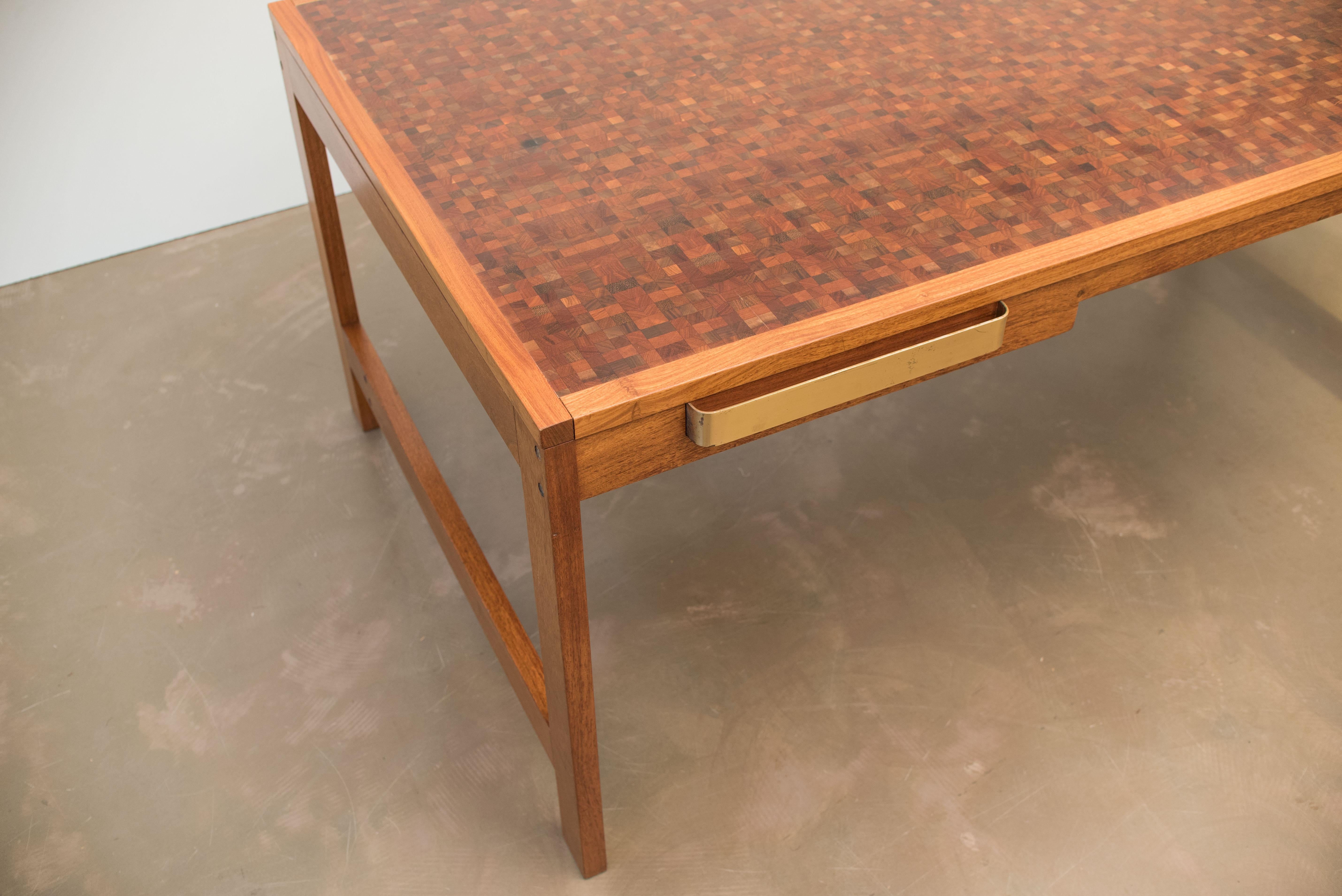 This Danish desk table features a tabletop with inlaid colored wood.