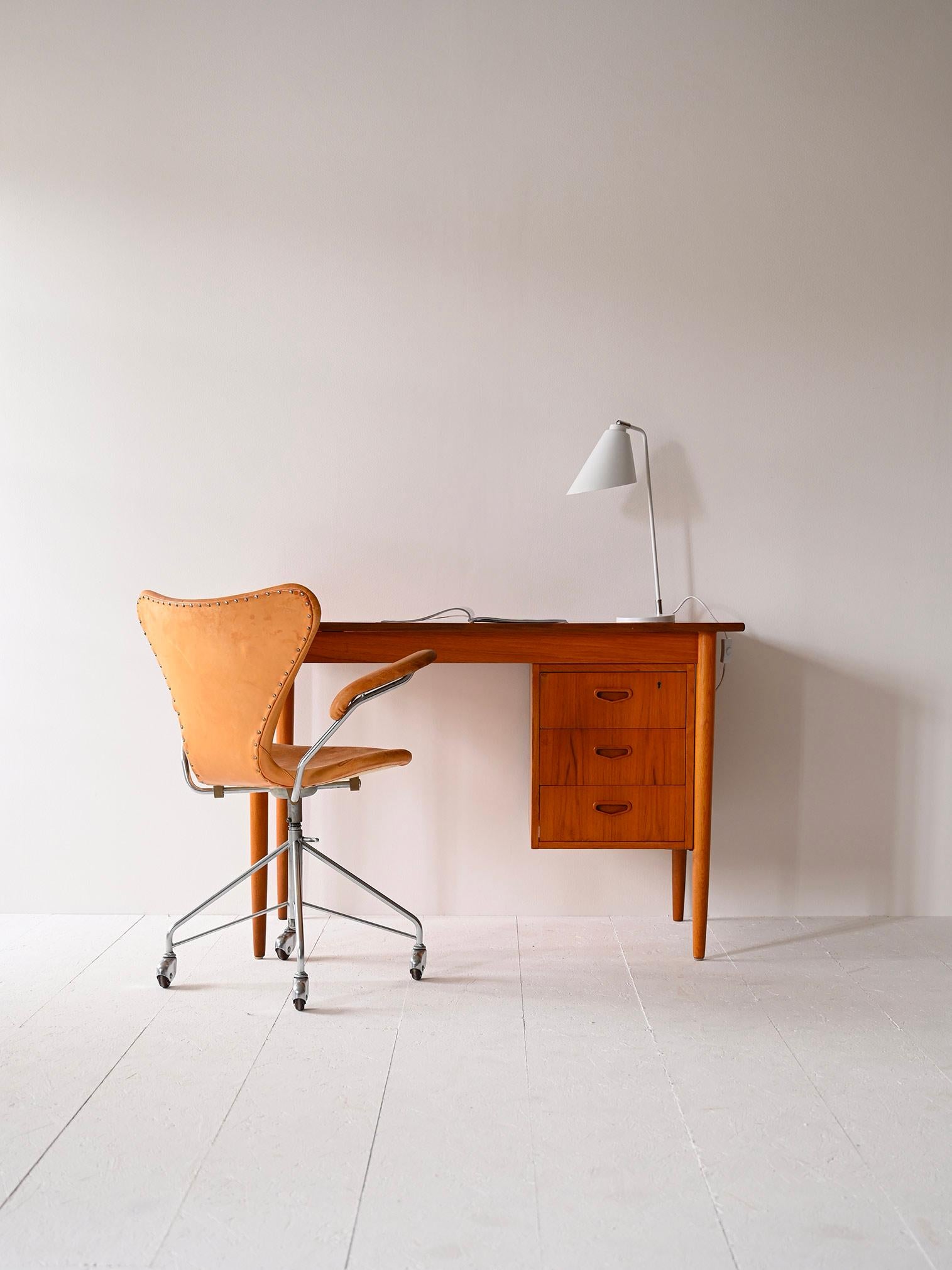 1960s office table.

A Scandinavian modernist piece of furniture that combines aesthetics and functionality.
It features a rectangular top 110 cm long and three convenient drawers, the first of which has a lock.
The frame is made of teak wood while